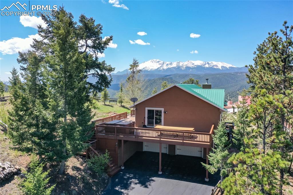 STUNNING PIKES PEAK VIEWS! This beautiful home in Paradise Estates and the surrounding mountains offers some of the best views in Woodland Park. This immaculate bi-level home has numerous upgrades to include: a 30 year Metal Roof, beautiful Hardwood floors in the upper level to include the kitchen and living room. The kitchen is appointed with all Stainless Steel Appliances including a gas range, microwave oven, refrigerator, dishwasher, under mount double sink, Granite countertops throughout and separate island with breakfast bar. Also included is a convenient pantry next to the refrigerator. Loads of cabinet space as well. The living room has a beautiful Moss Rock Fireplace with a gas insert. The room has large windows for your viewing pleasure as well as great natural light. There is a walk-out to an enormous deck with southwestern views with a great spot for entertaining throughout the year. There are 3 bedrooms on the upper level. The master suite walks out to the deck and hot tub. Master bath contains dual vanities, a walk-in shower with tile surrounds and radiant heated floor. 2 other bedrooms and a nicely appointed bathroom with granite counters and nice tile are located on the upper level. In the lower level you will find a cozy family room with an electric fireplace feature, a fourth bedroom, a bathroom, and laundry room. Additional storage can be found in the garage. There are actually 4 parking spaces. 2 inside the garage and 2 outside in the covered carport. The home is tastefully decorated with a warm color scheme and wonderful personal touches. The home is situated on a 0.83 acre lot to include a split rail fence. The landscaping is all natural and low maintenance. Wildlife abounds in the area. Come enjoy the allure of the Mountain Charm and the stunning vistas. Take a look at the Drone Video and 3D walk-through of the home. A floor plan is also attached for your reference. Come take a look at this wonderful home.