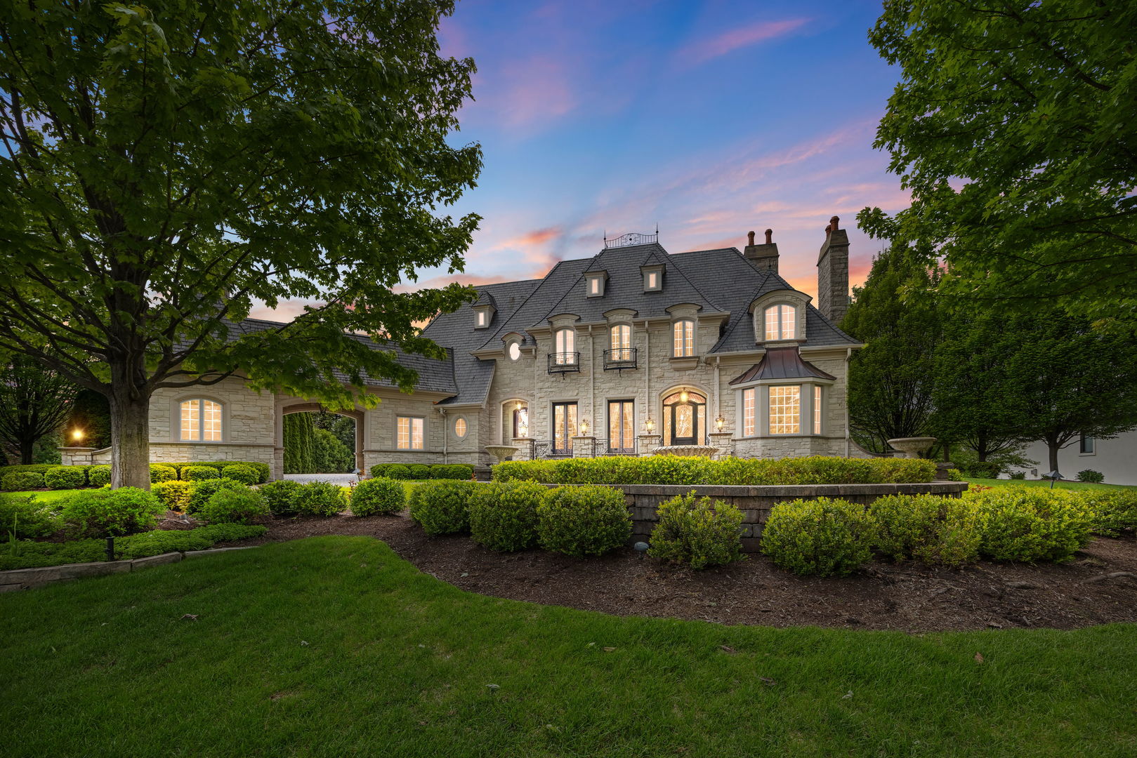 Welcome to one of Oak Brook's most extraordinary private estates, nestled on nearly an acre in the coveted Ginger Creek community. Offering the perfect blend of timeless elegance, resort-style amenities, and unparalleled craftsmanship, this remarkable stone residence delivers a lifestyle few homes can match.  From the moment you arrive, the heated circular driveway and impressive stone facade create a grand first impression. Beyond the doors awaits over three levels of meticulously designed living space, effortlessly connected by a private elevator and filled with exquisite details including marble and hardwood flooring, soaring coffered ceilings, custom millwork, architectural built-ins, and five inviting fireplaces.  Designed for both everyday luxury and unforgettable entertaining, the heart of the home is a stunning chef's kitchen featuring custom cabinetry, an oversized island, premium appliances, butler's pantry, walk-in pantry, wine refrigeration, and multiple dining spaces that flow beautifully for gatherings both large and intimate.  The home's flexible floor plan offers five spacious bedrooms, seven full baths, and three half baths, including a highly desirable main-level guest suite with adjacent sunroom. The lavish primary suite serves as a private retreat, complete with a spa-inspired bath and an extraordinary custom-designed dressing room and closet spanning more than 560 square feet.  Every level of the home offers something exceptional. Enjoy dedicated office spaces, recreation areas, a private fitness center, steam shower, soaking tub, salon space, theater room, game room, wine cellar, and beautifully finished upper-level living spaces designed to accommodate every lifestyle.  Step outside and discover what truly sets this estate apart. The spectacular backyard was designed to rival the world's finest resorts. Relax beside the sparkling pool, unwind in the hot tub and grotto, gather around the fire pit, entertain at the outdoor kitchen and bar, or host unforgettable evenings beneath the gazebo. Multiple terraces and gathering spaces create an outdoor experience that feels like a year-round vacation in your own backyard.  Every detail of this exceptional residence reflects uncompromising quality, comfort, and sophistication. Rarely does a property offer this level of privacy, luxury, and resort-style living in one of Oak Brook's most sought-after neighborhoods.  This is more than a home-it is a destination, a retreat, and a once-in-a-lifetime opportunity to own one of Ginger Creek's finest estates.