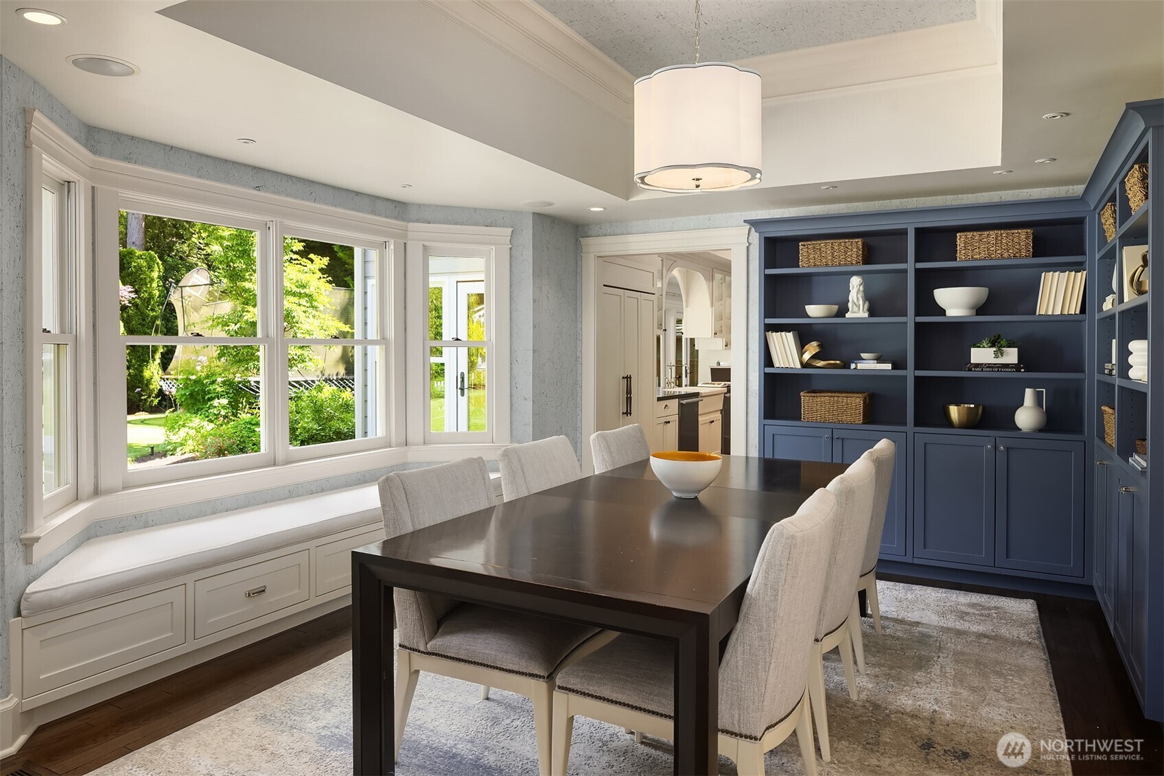Elegant dining room with a bay window banquette and custom navy built-ins