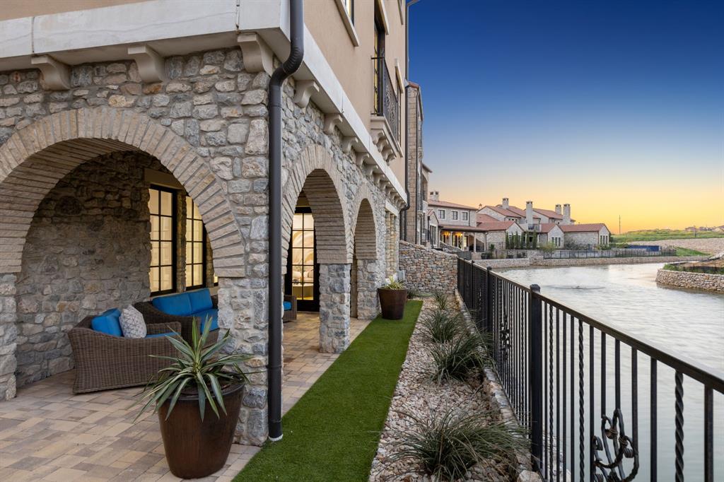 Nestled in the prestigious Westlake Entrada community, this extraordinary waterfront residence masterfully blends European sophistication with timeless Spanish architecture. Set on a picturesque waterfront lot, the home is thoughtfully designed to capture both grandeur and warmth. Inside, the spacious floor plan features four en-suite bedrooms, a dedicated office, and sun-drenched living spaces. French doors frame serene canal water views and seamlessly invite the outdoors in. The gourmet kitchen is outfitted with Wolf and Sub-Zero appliances—perfect for culinary enthusiasts. The primary suite serves as a private sanctuary, complete with a sun-kissed balcony overlooking the water, a spa-inspired bath, and an expansive walk-in closet. Exquisite luxury finishes throughout include white oak flooring, elegant lighting, and an elevator that adds both comfort and convenience. Entertain with ease in the game room, featuring a wet bar and wine refrigerator. Outdoors, a covered patio encourages alfresco dining and sunset gatherings, accompanied by the tranquil sound of nearby fountains. With its iconic tile rooflines, arched entryways, and artisanal wrought-iron accents, Entrada evokes the charm of a Catalonian village while offering a low-maintenance lifestyle. Enjoy close proximity to Westlake Lifetime Fitness, Southlake Town Square, and DFW Airport. Zoned for Carroll ISD or Westlake Academy—an exceptional location to match an exceptional home.