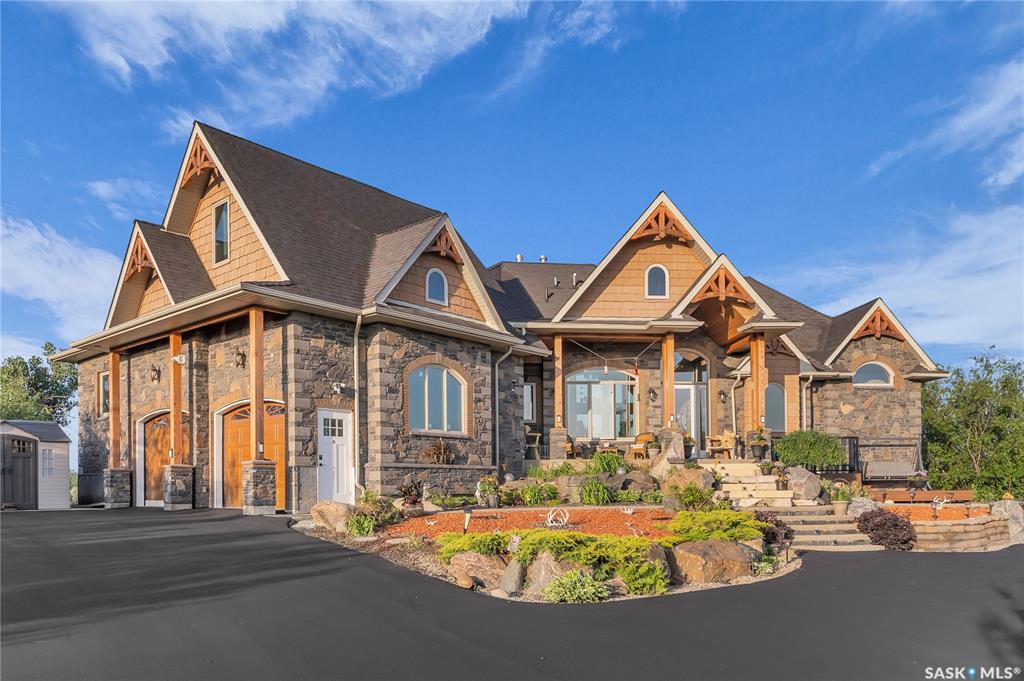 Live the Riverfront Dream. A Truly Exceptional Home. Set on an incredible 32-acre lot with 12 acres of private riverfront, you won’t find another property like this! Offering over 5000 sq ft of living space, the award-winning Durette Acreage makes an unforgettable first impression with its striking roofline and dramatic front elevation. Inside, soaring vaulted ceilings, stone fireplaces, and panoramic river views create a sense and scale with timeless style. While the craftsmanship and natural wood details ground the home bringing a feeling of warmth and intimacy. At the heart of the property is a space designed to bring everyone together: a custom walnut kitchen—seamlessly connecting to the family room and breakfast nook, which opens onto the wraparound balcony (a perfect spot for our Saskatchewan sunsets). The luxurious primary suite is sensational: coved ceilings, river views, spacious walk-in closet, and a spa inspired ensuite. Upstairs, a private loft suite with full bathroom offering options for bedroom or home office space. Downstairs, the 3 bedroom walkout level with its 9-foot ceilings opens into a large family room and games area, divided by a beautiful gas fireplace. A home theatre room is for the kids and the custom built wine room is perfect for wine lovers or collectors. Step outside into the acreage lifestyle of your dreams. You’ll find a handcrafted gazebo with a wood-burning fireplace. Peaceful corners for morning coffee. A lower patio designed for late-night s’mores and unforgettable family moments. Bold. Luxurious. One-of-a-kind. This isn’t just a house , it’s the place you’ll build a lifetime of priceless memories with your family.