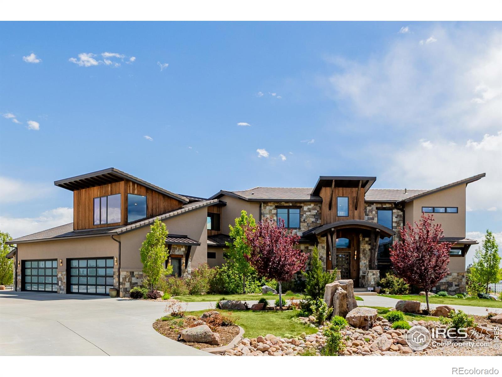THE FRONT RANGE ESTATE - Welcome to your luxurious retreat in the coveted Spruce Meadows neighborhood. This contemporary mountain-style home showcases unparalleled craftsmanship and attention to detail. Vaulted ceilings create a grand, spacious atmosphere, while walnut floors throughout the home, including the primary bedroom, add warmth. The gourmet kitchen is a chef's dream with Jenn-Air appliances, granite countertops, main and prep sinks, 2 dishwashers, 2 oversized islands, microwave/speed cooker, warming drawer, wine fridge, ice machine, and induction stove. The main-floor primary suite includes a cozy seating area, fireplace, a lavish bath with radiant floors, steam shower, freestanding tub, and dual sinks, and a grand walk-in closet with built-in dresser island and floor-to-ceiling shoe racks. The 4-car garage features 2 EV charging stations and ample storage. The polished concrete walk-out basement offers a full kitchen, home gym, bedroom, and bath. Upstairs, 3 en-suite bedrooms with walk-in closets and a loft with built-in desk and shelves provide space for relaxation. A dedicated office includes built-in storage and a half-bath. The backyard is perfect for entertaining with a lighted full-court basketball court with pickleball lines, a large TimberTech deck, sunken patio, and natural gas hookups for a grill and fire pit. The rounded driveway adds curb appeal. Experience luxury living at its finest-schedule your visit today. Property video link: