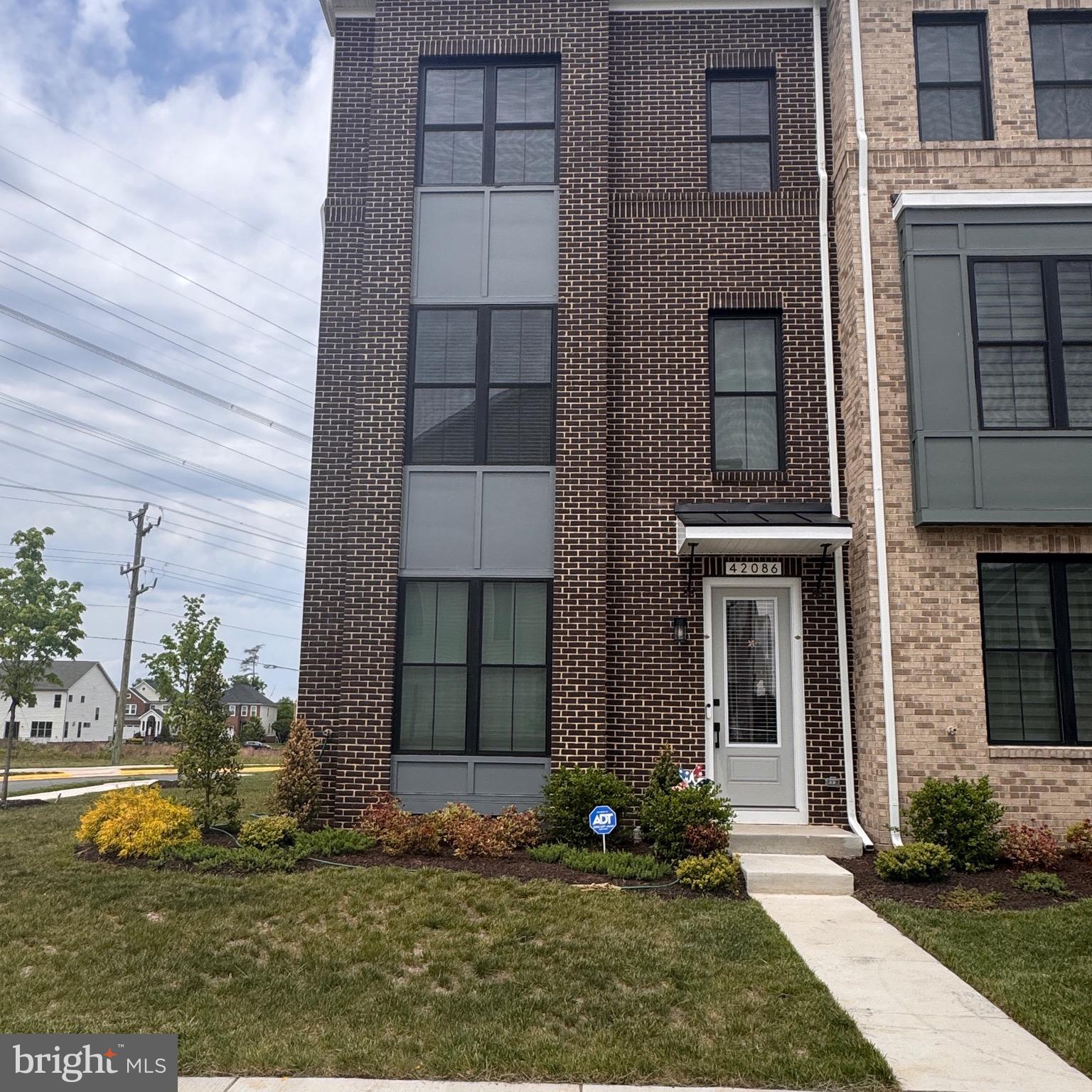 Built in 2025 by Van Metre Homes, this stunning Smith floorplan townhome at West Park III in the award-winning Brambleton community is the rare opportunity to own a brand-new home — without the new construction wait. Better yet, the builder's 12-month workmanship walkthrough is still available, giving the new owner full warranty coverage for interior finishes, surfaces, and systems. New construction protection, move-in ready.Spanning four thoughtfully designed levels, this 3 bedroom, 2 full and 2 half bathroom home with a 2-car rear-entry garage delivers the space and flow today's buyers expect. The heart-of-the-home kitchen is a true standout, featuring a large island, quartz countertops, upgraded cabinetry, and stainless steel appliances — equally at home for weeknight dinners or weekend entertaining. Soaring 9-foot ceilings and luxury vinyl plank flooring set the tone throughout the main living level, while the spacious great room and dining area flow seamlessly together. Upstairs, the primary suite is a genuine retreat, complete with a generous walk-in closet and a spa-inspired bathroom with double sinks and an oversized frameless shower. Two additional bedrooms and a conveniently located upper-level laundry round out the upper floors.The 2-car rear-entry garage keeps the streetscape clean and the curb appeal sharp — a detail that sets this home apart in the neighborhood.The Community — Brambleton, Ashburn's Gold StandardWest Park III sits within the vibrant, master-planned community of Brambleton — a family-friendly neighborhood offering miles of trails, tot lots, parks, five community pools, over 18 miles of paved trails, sports courts, and close proximity to Brambleton Regional Golf Course. With Brambleton Town Center just down the street, residents enjoy walkable access to shopping, dining, a movie theater, and everyday conveniences. For commuters, West Park is minutes from Metro's Silver Line, Dulles International Airport, and key commuter routes including the Dulles Greenway and Toll Road — putting the entire D.C. metro area within easy reach.Zoned for Madison's Trust Elementary, Brambleton Middle School, and Independence High School consistently among Loudoun County's most sought-after schools.The Warranty Advantage — Don't Overlook ThisMost buyers of new construction go through the builder's 12-month walkthrough themselves. Here, that window is still open for the new owner. Van Metre's warranty includes a one-year workmanship warranty on interior finishes and surfaces, a two-year systems warranty covering plumbing, electrical, and HVAC, and manufacturer warranties on appliances and equipment. This is builder accountability that transfers with the home — and it won't be available forever.