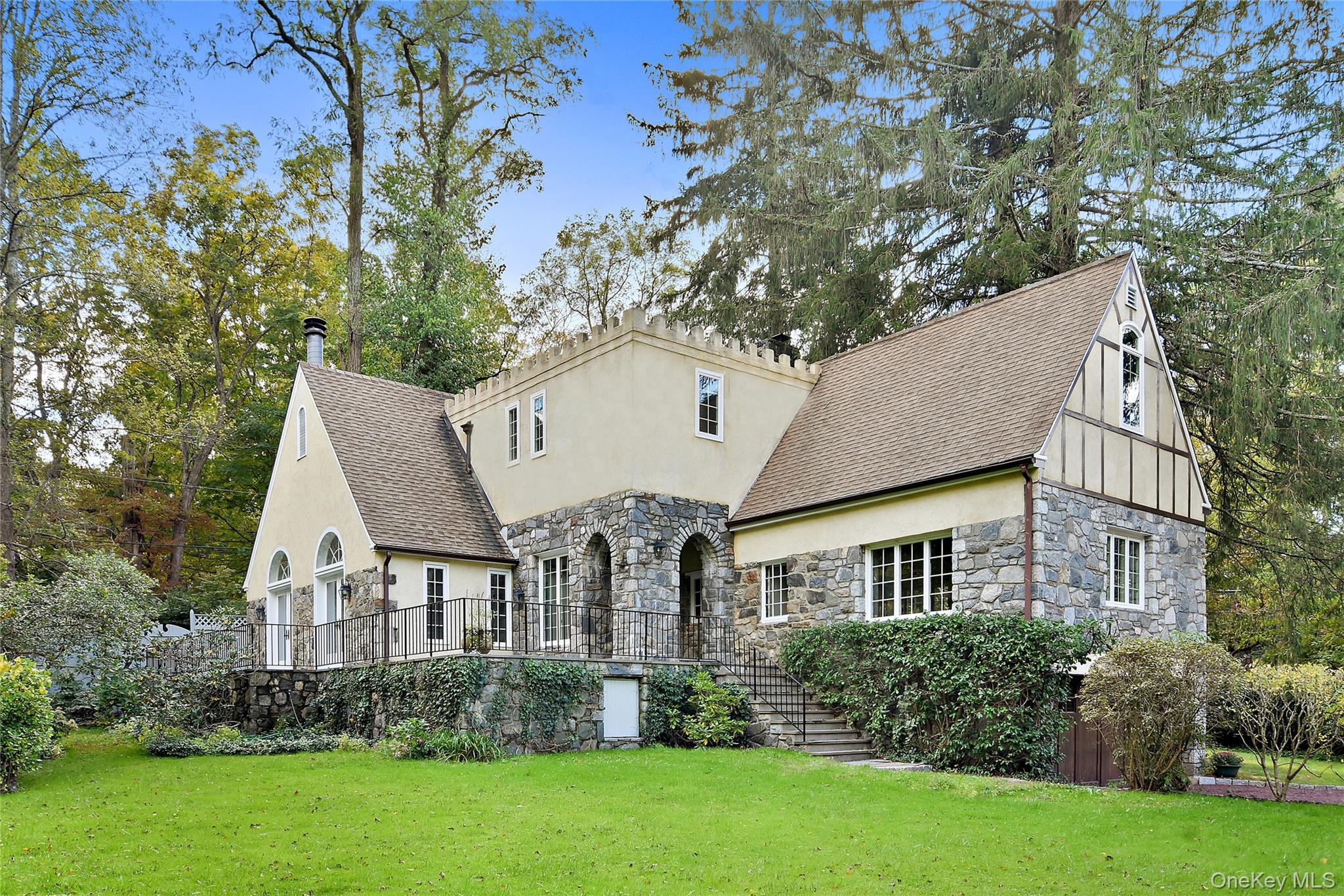 A storybook country retreat in the heart of Bedford.Tucked into a landscape that feels plucked from the English countryside, this stone and stucco residence offers a rare blend of romantic character and modern comfort. The property is just moments from the charm of Bedford Village and includes a picturesque pond and a bridge over a babbling brook.Inside, original arched doorways and exposed stone walls tell the story of exceptional craftsmanship, while the country kitchen invites gatherings with its wood-beamed ceiling, stone fireplace, and professional Vulcan range. Step outside to the stone terrace perfectly positioned to take in the natural landscape. Primary bedroom suite options on both the main level as well as the second floor (both with brand new baths).Fresh paint throughout means you can move right in and simply enjoy. A two-car attached garage completes the picture.