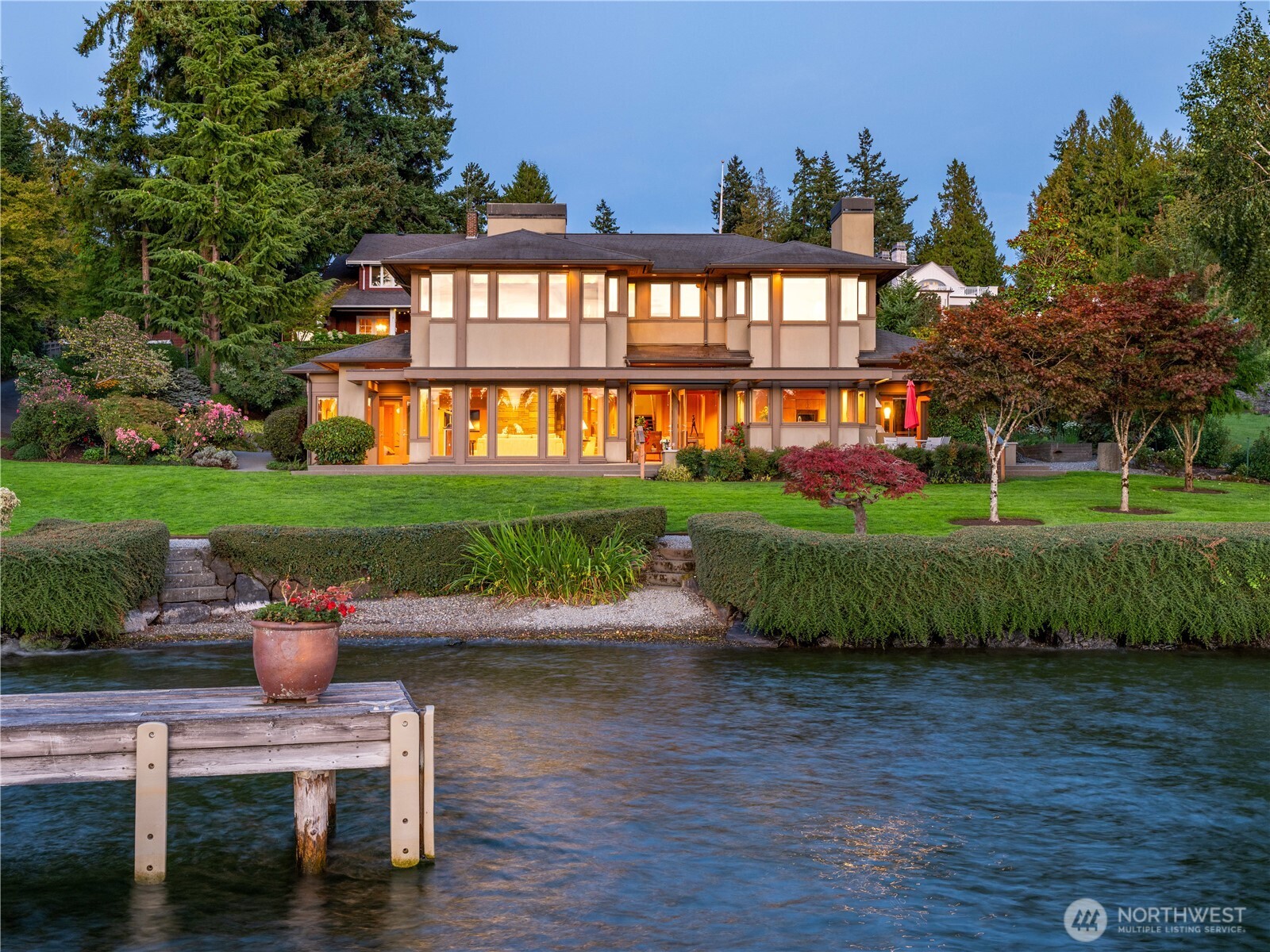 Perfectly balanced. Perfectly serene. Tucked away at the very end of a quiet lane, this 2003 AIA architect-designed home exemplifies Pacific NW waterfront living at its finest. Walls of west-facing windows frame sweeping lake views. Hardwood floors glow beneath hemlock paneled ceilings. Primary view suite includes study with fireplace. Living areas open seamlessly to a trellised terrace which steps down to an expansive gently sloping lawn. 109 feet of private, low-bank shoreline with easy to access, pebbled beach. Oversized shared dock with boat lifts complete the experience.Thoughtful design, enduring quality, and understated elegance, this residence embodies quiet luxury. A blissfully private sanctuary in harmony with its verdant setting