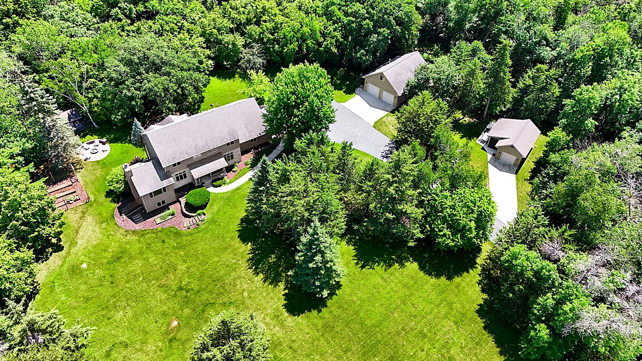 Available for the first time, this exceptional two-story home is perched on 7.5 private wooded acres with breathtaking western views stretching beyond Richmond! The property is a dream for hobbyists, car enthusiasts, or anyone needing premium workspace, featuring a heated and finished triple attached garage, an impressive 28x36 heated and finished shop with loft, plus a 14x28 garage/garden shed with an attached screened porch. Inside, the meticulously maintained home offers 9-foot ceilings and real hardwood floors on the main level, a spacious kitchen with beautiful rift-sawn cabinetry, granite countertops, stainless steel appliances, a 36-inch gas cooktop, and both formal and informal dining areas. The inviting living room opens to a vaulted sunroom with a real wood-burning fireplace, while the main level also includes laundry and a flexible den that could serve as a fifth bedroom. Upstairs you'll find four bedrooms, including a spacious primary suite with vaulted ceiling, walk-in closet, and private bath featuring dual granite-topped vanities, a tile shower, and in-floor heat, which is also found in the second upper-level bath. The finished lower level offers new carpet, a large family room with a gas fireplace, recreation room, dedicated office, craft room, and abundant storage. The home was painted inside and received a new furnace and central air conditioner in 2025. Completing this remarkable property are a firepit and a handcrafted wood-fired sauna featuring a Finnish sauna stove, creating the perfect retreat to enjoy this one-of-a-kind setting.