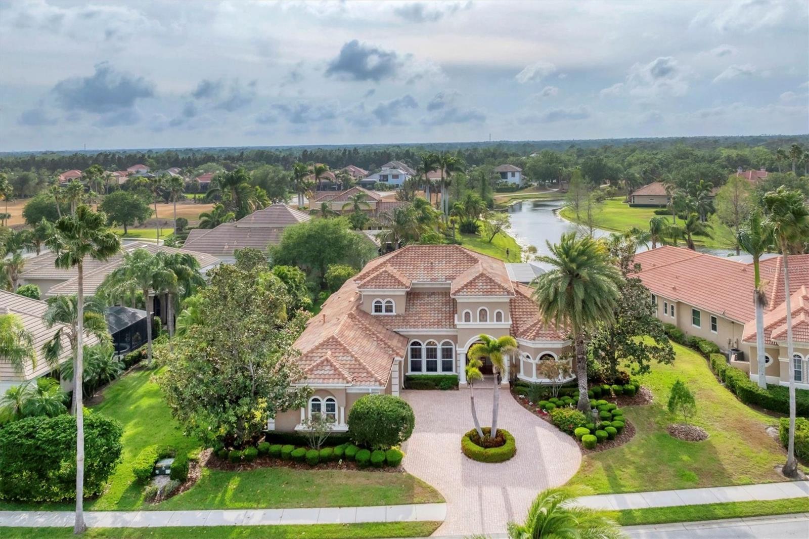 An amazing family resort style home, located in The Dominion, one of the most desirable neighborhoods in Lakewood Ranch Country Club! This Todd Johnson masterpiece features the perfect floor plan, flexible, spacious and maximizing the enjoyment of the serene and peaceful lake, preserve and golf course views.
This four-bedroom, five-and-a-half-bath home showcases stunning architectural details including intricate crown moldings, tray ceilings, stately all wood built-ins and 2 cast stone fireplaces, one in the living room and the other on the spacious lanai. The chef's kitchen features all wood quiet close cabinetry, new Subzero refrigerator and freezer, GE Monogram double ovens, GE Monogram 6 burner range and a newly redesigned kitchen island with gorgeous rich chocolate brown quartz countertops and custom backsplash make this kitchen one to remember. The owner’s retreat boasts wood flooring with an extended sitting area, large his and hers walk-in closets and a lavish master bath with dual marble vanities, exquisite wood cabinetry including linen towers, large walk-in shower with intricate tiling and jetted soaking tub so one can truly relax and unwind. Situated on the other side of the home for complete privacy the mother-in-law suite is perfect for that long term guest with an ensuite full bath, mini refrigerator with room for a coffee bar, beautiful bay windows framing the sitting area and a built-in desk with elegant all wood cabinetry and storage. Towards the back of the home, you will find another guest suite with full bath and a spacious office with large picture window overlooking the expansive lake view.
As you make your way upstairs, you will notice the intricate iron railing leading you to the open bonus room with private guest suite with a full bath and covered balcony. Back on the first-floor, exit through the disappearing sliders from the great room to the beautiful outdoor living space with spectacular lake view, where you can refresh in the saltwater, heated pool and spa and sit back under the huge, covered lanai with spectacular outdoor kitchen with 2 refrigerators, grill, boiler, sink and stunning cast stone fireplace.  OTHER NOTABLE FEATURES INCLUDE:  new pool heater in 2025, landscape lighting throughout the yard, newer carpeting in guest bedrooms, AC units replaced in 2024 and 2025, new Subzero refrigerator Dec. 2024, newer dishwasher 2018, new screening on lanai cage in 2023 and 6 video surveillance cameras for your peace of mind.  Lakewood Ranch Country Club offers the ultimate Florida lifestyle with a private Country Club with 3 luxurious clubhouses, 4 golf courses, 18 Hard-Tru lighted tennis courts, pickleball courts, state of the art fitness center, aquatic center, parks, walking trails and so much more. Membership is optional and no waitlist. All within minutes of the UTC Mall, fabulous dining and shops, Lakewood Ranch Main Street, polo fields, Benderson Park, and the much-anticipated new home for Mote Marine Aquarium. Plus, don't forget you're only a short drive to the world's top-rated beaches! This is truly luxury at its finest, schedule your private showing today.