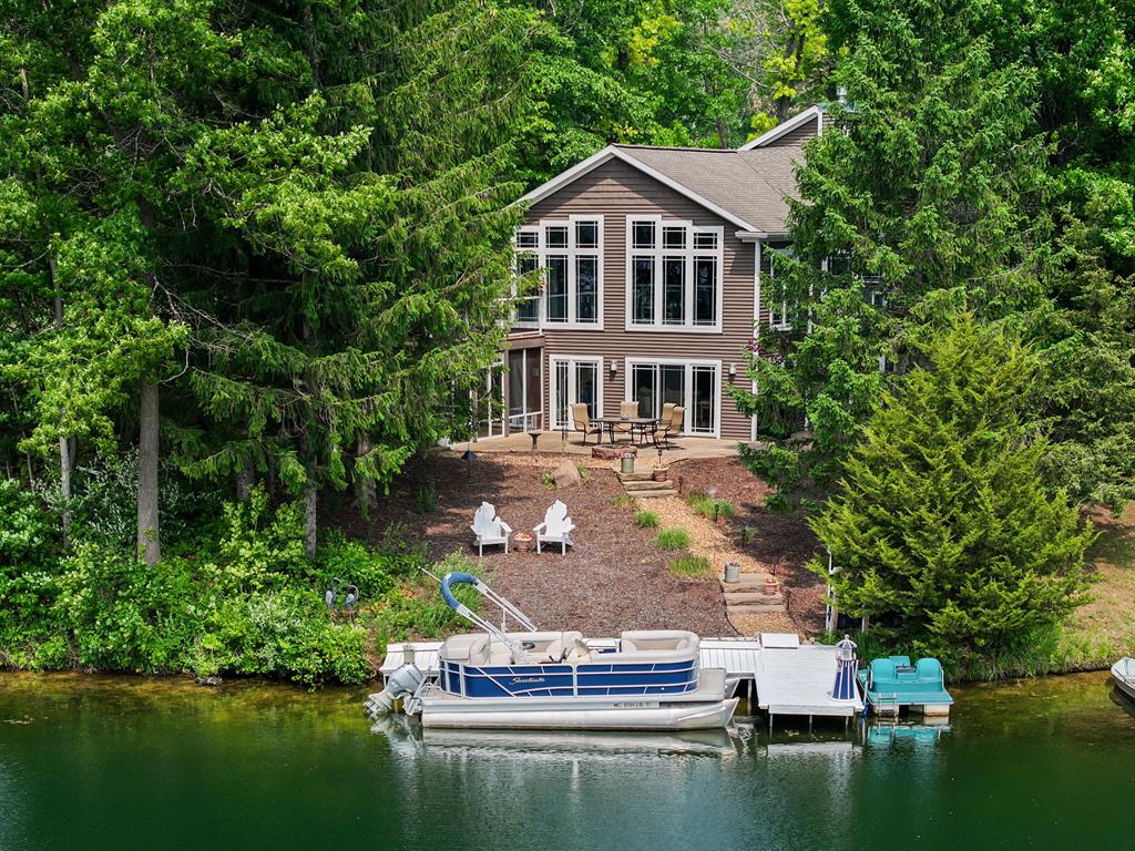 Welcome to 295 West Shore, a truly exceptional lakeside retreat featuring 94 feet of private frontage on stunning Mirror Lake. This isn't just a home; it's a lifestyle, offering world-class fishing, all-sports boating without the distraction of jet skis, and a private beach park perfect for kids, along with fantastic kayaking opportunities.A true staple of the lake, this home was meticulously designed and built as if pulled from the pages of a luxury magazine. Step inside and be immediately captivated by the amazing open-concept layout, where gleaming wood floors and soaring vaulted ceilings draw in an abundance of natural light - the very essence of a perfect lake home.Glass railings to the lower level create a seamless flow and ensure the breathtaking lake views are enjoyed from every vantage point, allowing the lower level to share in the main floor's bright ambiance.

The gourmet kitchen is a chef's dream, boasting exquisite stone countertops, top-of-the-line appliances, unbelievable tile work, and custom glass-faced cabinetry that adds a touch of bespoke elegance. The master suite is a sanctuary that spared no expense, featuring its own private walkout to the lakefront and an absolutely stunning shower with impeccable tilework. This same artistry in tile will also be admired on the one-of-a-kind fireplace, which showcases a custom lake scenery design.

The lower level is an expansive, wide-open space mirroring the beauty above, with floor-to-ceiling windows that perfectly frame the lake views. Entertain guests at the stylish wet bar, equipped with its own beverage coolers, stone countertops, and custom backsplash tile work. A bonus cedar sunroom provides an additional tranquil space to relax and soak in the surroundings. Walking out of the lower level you will notice stamped concrete with matching steps all around the home and down to the lake. 
Above the garage, a finished living space offers extra versatility, with mini-split unit lines already run for added comfort if desired.
This home is packed with tho