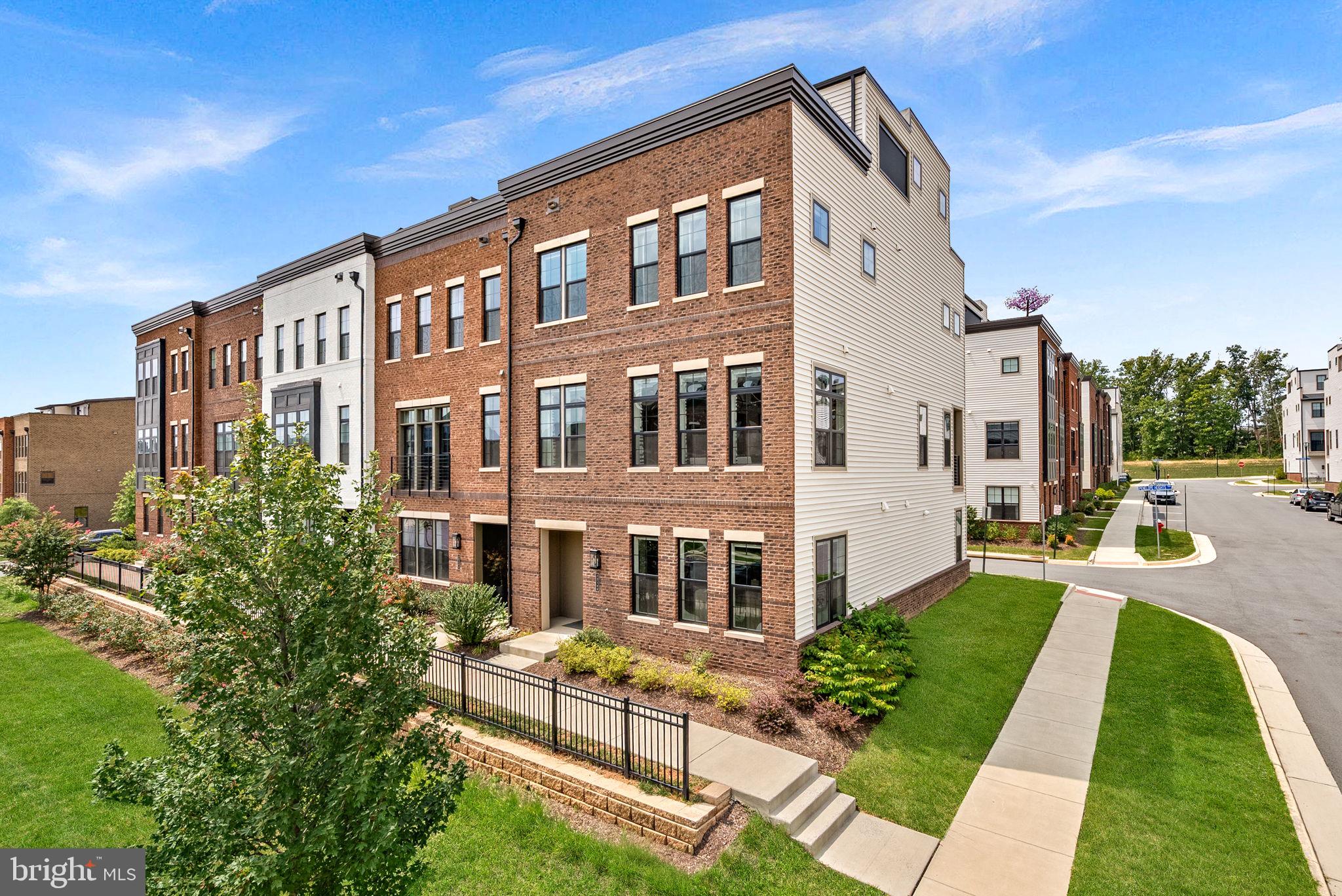 Luxury, sophistication, and modern convenience come together beautifully in this exceptional end-unit townhome in the prestigious Metro Walk at Moorefield Station. Built in 2022 and enhanced with more than $100,000 in improvements, this one-of-a-kind residence offers over 10-foot ceilings, designer finishes, automatic window shades throughout, and thoughtfully curated living spaces on every level.The open-concept main level is designed for effortless entertaining. The gourmet kitchen features upgraded countertops, stainless steel appliances, a five-burner gas range, double wall ovens, and an impressive waterfall island. The kitchen flows seamlessly into the spacious family room and dining areas, while a built-in wine refrigerator adds the perfect finishing touch for hosting family and friends.The home offers four generously sized bedrooms, three full bathrooms, and two half bathrooms. The luxurious primary suite is a private retreat featuring a custom-designed walk-in closet and a spa-inspired bathroom with an oversized walk-in shower. Elegant wood-look flooring, recessed lighting, and an integrated sound system further elevate the home’s refined atmosphere.The loft level provides an extraordinary entertainment experience with a built-in theater system concealed within the ceiling. Step outside to the spectacular rooftop living space, designed for year-round enjoyment. Multiple balconies and a screened terrace provide even more opportunities for outdoor dining, relaxing, and enjoying beautiful sunrises and sunsets.The fully finished lower level features daylight windows and direct garage access, offering flexible space for a home gym, recreation room, private office, guest suite, or additional bedroom. An attached two-car garage includes additional storage for everyday convenience.Residents of Metro Walk enjoy access to outstanding community amenities, including a clubhouse, fitness center, outdoor pool, and picnic areas. Located within walking distance of the Ashburn Metro Station and less than five miles from Washington Dulles International Airport, this home offers exceptional accessibility without sacrificing luxury.From its soaring ceilings and modern comforts to its rooftop retreat and extensive custom upgrades, this remarkable home truly oozes luxury and sophistication. More than a residence, it is an elevated lifestyle—and an opportunity unlike any other.