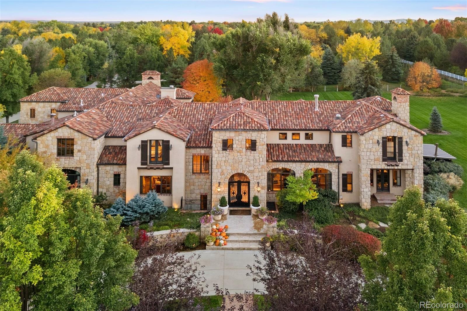 Behind wrought iron gates and a circular drive lies this exceptional estate set across nearly 2.5 professionally curated acres, offering privacy and convenience. A grand entry introduces the home’s architectural pedigree, where stone and reclaimed hardwood plank flooring set a warm, refined tone. Imported materials, custom millwork, architectural beams, and designer fixtures speak to a depth of quality felt at every turn. Dual staircases, exquisite doors, and thoughtful detailing create both presence and flow.The chef’s kitchen is the heart of the home, featuring dual islands with seating for six, slab stone countertops, custom cabinetry, Wolf 6-burner range with griddle and pot filler, SubZero refrigeration with additional drawers, two dishwashers, warming drawer, and walk-in pantry. Breakfast and hearth rooms overlook the grounds. The two-story family room showcases a stone fireplace, floor-to-ceiling windows with French doors opening to terraces & gas fire pit. A statement bar with backlit slab detail, ice maker & more enhances the entertainer’s appeal.  Formal living and dining rooms, butler’s pantry, wine room, private office with fireplace, guest suite, mudroom and powder baths complete the main level.  The lower level offers a recreation room with fireplace and full bar, home theater, game room, exercise studio, wellness retreat, and guest suite.  Upstairs, four secondary bedroom suites each offer unique finishes and private baths near an oversized loft and laundry with dual washer & dryer. The primary suite is a true retreat with fireplace, sitting room & private balcony.  The spa-inspired bath rivals a five-star resort, featuring heated flooring, handmade tiles, steam shower, & soaking tub room to name a few.  Outdoor amenities include a pool and spa, outdoor kitchen, fully fenced grounds with irrigation well and an oversized six-car heated garage. This is more than a residence, it's an experience that delivers warmth rarely found at this scale.