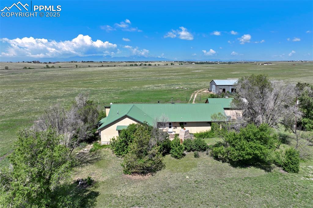 Welcome to a legacy of Colorado living, where modern comfort meets timeless land. Nestled on 80 sprawling acres of fully fenced, horse-ready prairie, this extraordinary property tells a story generations in the making. Once part of an 1800s homestead, the soul of the land is still present in the original lilac bushes that bloom near the home each spring, and in the hand-selected wood accents carried throughout the house—reclaimed from the very homestead that stood here before.  |  Inside, the home is a masterclass in warmth and thoughtful design. The open-concept main level was built for easy, single-level living. A spacious kitchen serves as the heart of the home, complete with a built-in island, breakfast bar, and gas stovetop. The primary suite is a true retreat, featuring a look-through fireplace, bay window with built-in storage, walk-in closet and second hidden (lockable) closet, plus a private bath with a jetted soaking tub. A second en-suite bedroom offers added flexibility for guests or multigenerational living. Natural light pours into the south-facing sunroom, while the office is outfitted with custom shelving which invites productivity. The unfinished basement offers plenty of room to grow.  |  Outside, the possibilities are endless. A custom stone patio with fireplace sets the scene for memorable nights under the stars. A metal outbuilding with concrete floors provides storage or workshop space. The barn includes stalls, a tack room, chicken coop, with water and electricity. Zoned for horses and livestock and split into two 40-acre parcels, the property even has a 500-yard range on-site and offers the option to purchase an additional 40-acre parcel directly to the west. A rare blend of history, utility, and wide-open freedom—this is where your Colorado dream takes root.  |  Approximately 10 minutes to Schriever Space Force Base, 20 mins to Peterson SFB, 10 minutes to the town of Falcon, and 30 minutes to Colorado Springs.