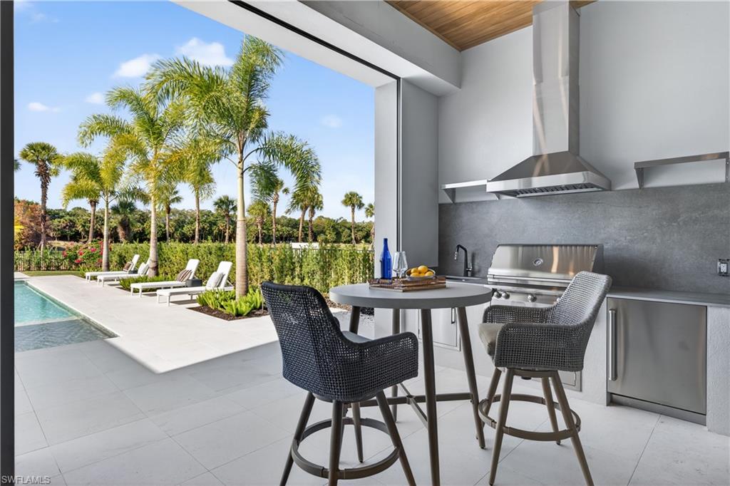 View of patio / terrace featuring exterior kitchen and an outdoor pool