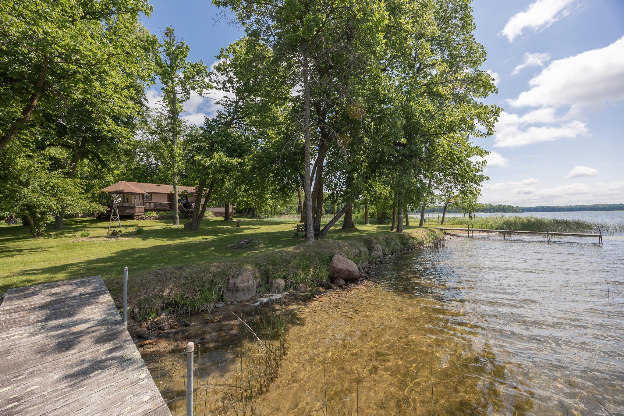Set on 6.50 private acres with an incredible 1,083 feet of level, no-elevation shoreline, this property offers a rare stretch of lakeshore on one of Minnesota’s sought-after lake chains. Woman Lake, connected to Girl and Child Lakes, offers over 30 miles of shoreline, making for excellent boating, fishing, and some of the clearest waters in the region.  It’s also a canvas for your dreams. The setting is truly something special: wide-open views, a hard-bottom lakeshore perfect for swimming, and the natural soundtrack of Red-Winged Blackbirds calling from the nearby marsh. Out every window: privacy. Out every door: opportunity. The existing structure includes three bedrooms, a kitchen with ample cabinetry and peninsula seating, large lake-facing windows, and a lower-level walkout with a pellet-burning fireplace. While the home provides a footprint and utilities, some may see this as a rare tear-down opportunity to create something spectacular in an unbeatable location. Whether you imagine updating the current home or designing something entirely new, this is a rare opportunity to own expansive acreage and premier shoreline on the Woman Lake Chain, where privacy, beauty, and potential come together. Properties like this don’t come around often. Build your legacy on Woman Lake.