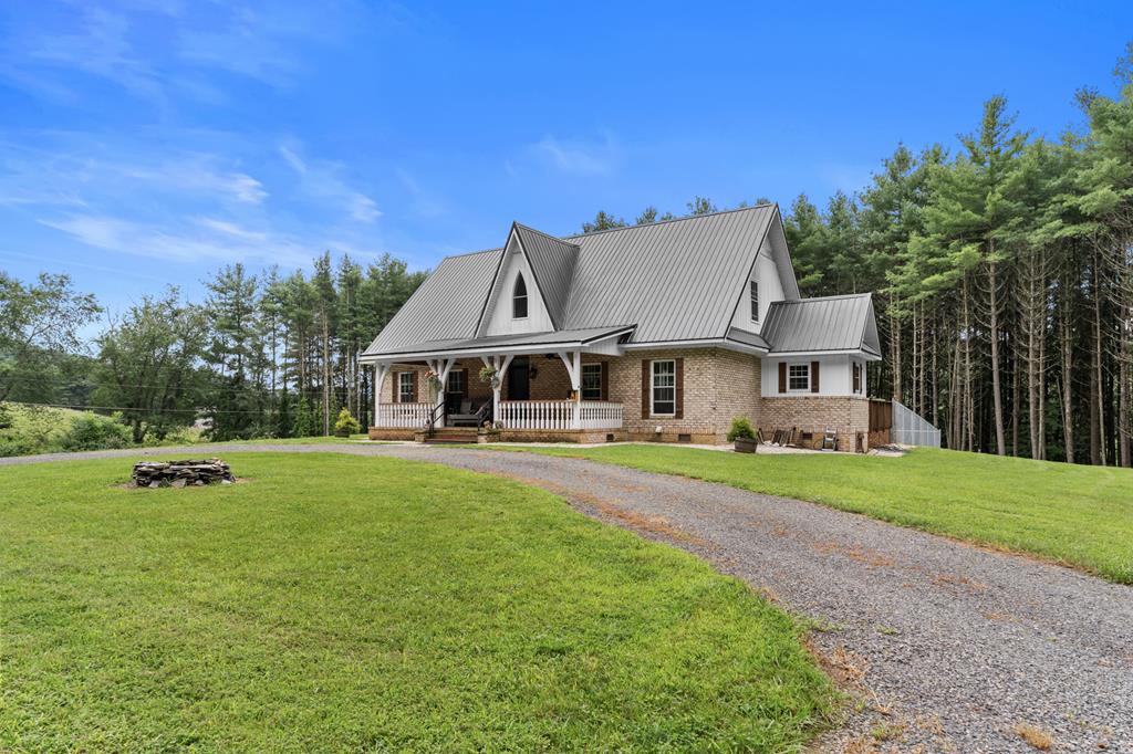 Custom-Built Home in the Town of Hillsville. Enjoy the privacy and seclusion of the countryside with the convenience of town living in this well-built custom home. Sitting on 5.2 acres, this spacious 2,720 sq ft home offers 3 bedrooms and 2 bathrooms, thoughtfully designed for comfort and functionality. Step inside to an inviting open floor plan featuring 9-foot vaulted ceilings. The main level includes a generous living room, dining area, guest bathroom, and a beautiful kitchen with granite countertops, a farmhouse sink, walk-in pantry, laundry room, and pellet stove. The master bedroom and bath, also on the main level, features two large walk-in closets, a luxurious bathroom with a marble walk-in shower, and a free-standing soaking tub—perfect for unwinding after a long day. Upstairs, you'll find two spacious bedrooms and a versatile loft area ideal for a home office or reading nook. Outdoor living features with a 10' x 30' covered front porch, perfect for morning coffee or taking in the fresh mountain air. The 8' x 42' open back deck is made for entertaining, offering plenty of space for cookouts with friends and family. Additional features of this lot include a circle driveway, a balanced mix of open yard and wooded areas with apple, pear, and peach trees. A partially fenced backyard with raised garden beds great for gardening or keeping pets safe, new greenhouse with electric for year-round growing, wired metal building ideal for a workshop or additional storage. Located just five minutes from restaurants, schools, shopping, and the Wellness Center, with easy access to I-77, Mt. Airy, and Wytheville.