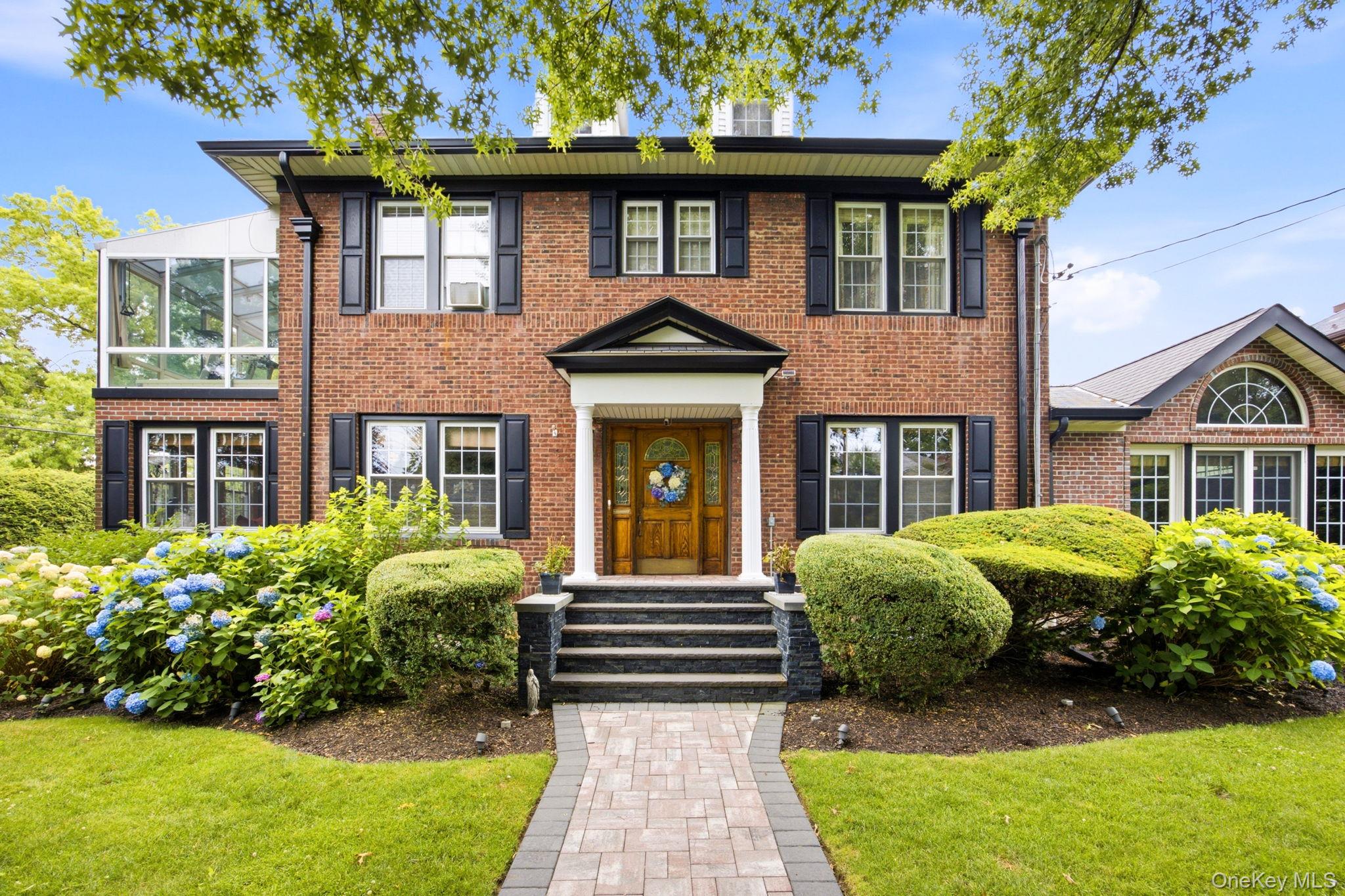 A truly rare offering and the last of its kind, this fully detached Center Hall Colonial in Weeks Woodland sits on an extraordinary double lot measuring 106' x 100' , presenting a unique opportunity for both luxury living and future development potential. Meticulously maintained and rich in character, the residence offers three spacious bedrooms, three and a half bathrooms, formal living and dining rooms, and multiple gathering spaces designed for both everyday comfort and elegant entertaining. A warm dual sided gas fireplace anchors the den & formal living room, while the impressive Great Room, complete with a wood-burning fireplace, creates the perfect setting for memorable family gatherings. An enclosed upper-level porch provides flexible space for a sunroom, fitness studio, home office, or wellness retreat. The finished lower level includes an additional concourse suite with a private entrance and full bathroom, offering exceptional versatility for extended family, guests, or multi-generational living.Outside, a gated private driveway accommodates up to four vehicles and leads to a coveted two-car garage, with potential to convert the existing structure into an Auxiliary Dwelling Unit (ADU), subject to applicable approvals. The expansive backyard offers a private oasis with ample room for outdoor entertaining, recreation, and future possibilities. Recent capital improvements include recent woodworking, recent painting, new wallpapering, a new boiler and hot water heater installed in 2025, along with HVAC servicing the lower and main levels. Located within highly regarded School District 26 and just moments from over 100 acres of parkland at John Golden and Crocheron Parks, as well as Little Neck Bay and Marina, this exceptional residence combines timeless architecture, unmatched lot size, and an enviable lifestyle in one of the area's most sought-after neighborhoods.