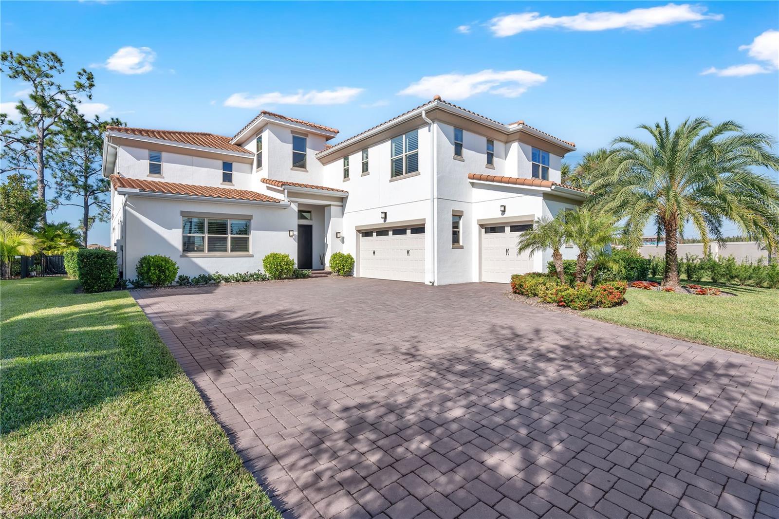 Set along the shoreline of Lake Hickorynut in Avalon Cove, this 2022-built lakefront residence blends refined design with the ease of modern Florida living. Positioned on a cul-de-sac corner lot of approximately 0.35 acres, the home offers long, open-water views and a lifestyle centered around indoor–outdoor connection, afternoon breezes off the lake, and sunsets enjoyed from the covered balcony or the resort-style pool terrace.The home spans approximately 4,934 square feet of living space (total 6,907 square feet), with five bedrooms and five full baths, and features tall ceilings, expansive windows, and sliding glass doors that frame the water view from the main living areas.The main level includes an open kitchen with upgraded cabinetry, soft-close doors and drawers, an oversized island, a natural-gas cooktop, a walk-in pantry, and a glass-enclosed wine room. An electric fireplace anchors the family room, and double sliding barn doors open to a dedicated theater room equipped with a projector, automated screen, and integrated sound.A first-floor guest suite with a walk-in closet and an additional full bath is perfect for visitors or multi-generational living. A large flex space, currently used as a gym, completes the first floor.Upstairs, a spacious loft with custom cabinetry, beverage drawers, and a triple-TV setup leads to the 40-foot covered balcony overlooking the lake — perfect for enjoying the sunset. The primary suite shares the same view and offers a large spa-style bath with a freestanding tub, an oversized shower with multiple shower heads, dual sinks, and a walk-in closet with built-in storage and direct access to the laundry room. Three additional bedrooms and two more full baths are also located on this level.The fenced backyard is designed for low-maintenance year-round enjoyment, featuring turf, lush landscaping, and a custom outdoor kitchen under the covered lanai. The natural-gas heated pool includes a waterfall, bubbler, oversized spa, built-in table with umbrella, sun shelf, lighting, auto-fill and drain, and complete smartphone control. A composite, covered dock — built in 2022 — extends the lifestyle onto the water with a boat lift, electricity, water, and rail lighting.Additional features include an EV charging station in the oversized three-car garage, custom garage cabinetry with a dedicated workbench, plantation shutters, upgraded tile plank flooring on the first floor with hardwood upstairs, a tile roof, smart-home systems (Control4, Lutron lighting, and Sonos), a water filtration system with reverse osmosis, and a security system with video capability.Located minutes from great schools, dining, parks, and attractions in Horizon West, this lakefront home offers both privacy and connection in one of Winter Garden’s most desirable areas.
