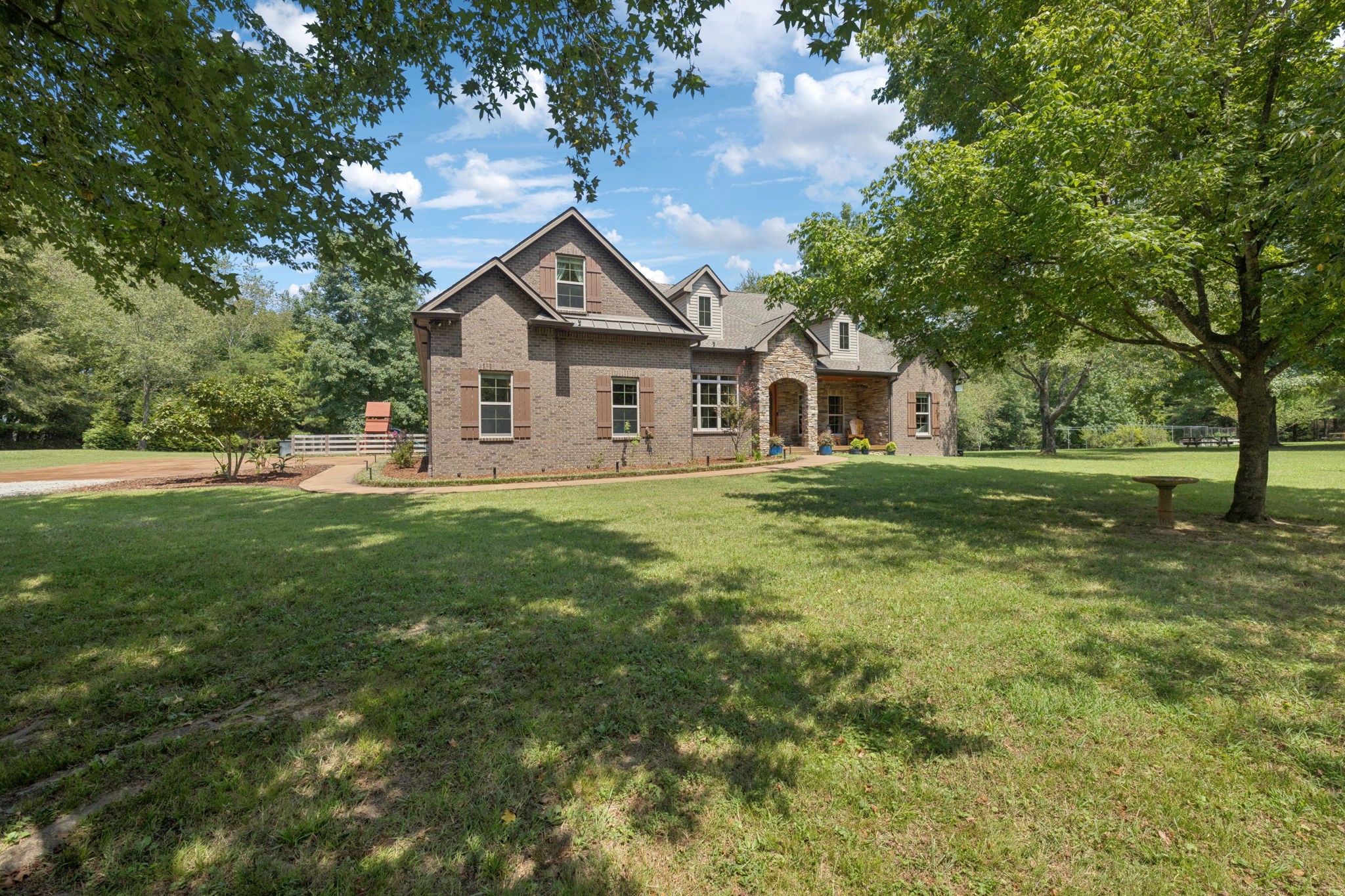 Open House FEEDBACK: The most beautiful home I have visited in TN-Cindy. Immaculate, 5/5 in all categories-Lisa.

     Experience refined country living at this stunning 12+ acre gated estate near Fairview’s vibrant core. The elegant brick home blends timeless charm with modern convenience, offering a luxurious, serene retreat. The gourmet kitchen with modern appliances opens to a spacious great room. The main-level primary suite features a spa-like en-suite bathroom including an air bathtub and large walk-in closet. Two additional main-level bedrooms, each with private en-suite bathrooms and walk-in closets, ensure privacy. A sophisticated library, formal dining room, hardwood floors, and crown molding add warmth and elegance. App-controlled Sonos surround sound across seven zones and elegant lighting enhance the experience. Upstairs, a spacious media/recreation room, a large bedroom with a walk-in closet, and a full bathroom offer flexibility. A large walk-in attic provides ample storage. The highly versatile acreage is ideal for outdoor enthusiasts, featuring a lush pasture, serene forest, new greenhouse, woodshed, machine shed with lean-to, and a deluxe chicken coop with 12 nesting boxes, electricity, Wi-Fi, and water. A blueberry patch and 30’ irrigated raised flower bed cater to gardeners. The fenced, irrigated backyard includes a play structure, custom patios, a BBQ pavilion, and space for a future spa. High-speed fiber internet supports remote work, and a below-ground storm shelter ensures safety. Separate utilities allow for farm use or a potential secondary residence. Enjoy abundant wildlife, serene privacy, and nearby amenities. The solar-powered gate with remote Wi-Fi and camera, along with city water, sewer, and natural gas, adds convenience. This Fairview estate combines rural charm, modern luxury, and timeless sophistication for discerning buyers. Step into your dream home today!