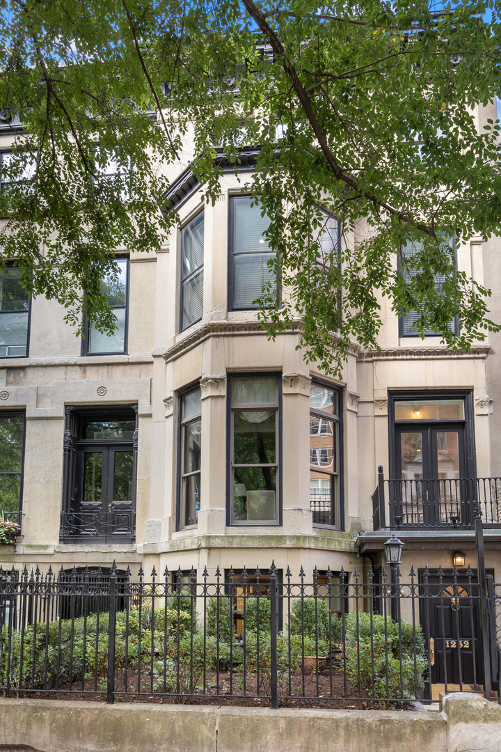 Dramatic Gold Coast 5 bed/5.2 bath limestone end-unit row house at 1252 N State Parkway! This architecturally significant home was built in 1872 just after the Chicago fire by famed developer Potter Palmer and designed by architect David Adler. This impressive home offers 5000 sq. ft. over 4 levels plus a coach house apartment.  It's modern layout is ideal for entertaining, while still showcasing many of its original details by paying homage to staircases, millwork, brass hardware, and marble fireplaces.  The kitchen features professional grade Sub-Zero and Viking appliances, a spacious island with a prep sink, and additional wine and refrigeration drawers.  Notable master suite, utilizing the entire third level, is lined by oversized bay windows overlooking the lush tree-lined street below and includes dual walk-in closets and dual en-suite baths. 4 levels are complemented by a 1-bedroom coach house attached via an indoor heated walkway that also leads you to your own heated 2 car garage! Plenty of outdoor space from the front balcony to the rear deck, plus an internal balcony that overlooks a private interior courtyard. On one of the best streets in the Gold Coast, only steps to the shopping and restaurants, the lakefront trail, and Lake Shore Drive.