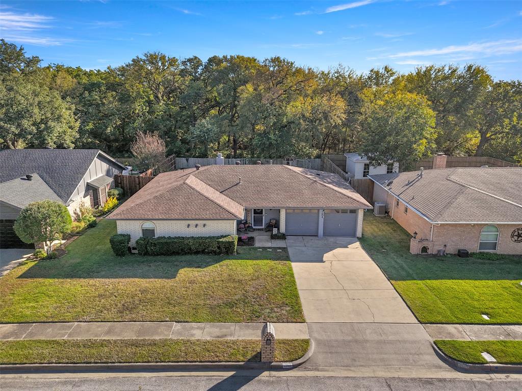 Well-maintained, North Facing, 3-bedroom, 2-bath home with a large backyard backing onto treed green space. Features luxury vinyl plank flooring (no carpet), cathedral ceiling and brick gas fireplace in the living room, separate dining area, and laundry room. The spacious master suite includes an ensuite bath and two walk-in closets; secondary bedrooms also have walk-in closets and ceiling fans. Backyard offers a wood deck, firepit, and ample space for a pool or recreation. Local park is visible from the front yard and just a short walk away. Convenient to major highways, DFW airport, shopping, and schools.Home is move-in ready!