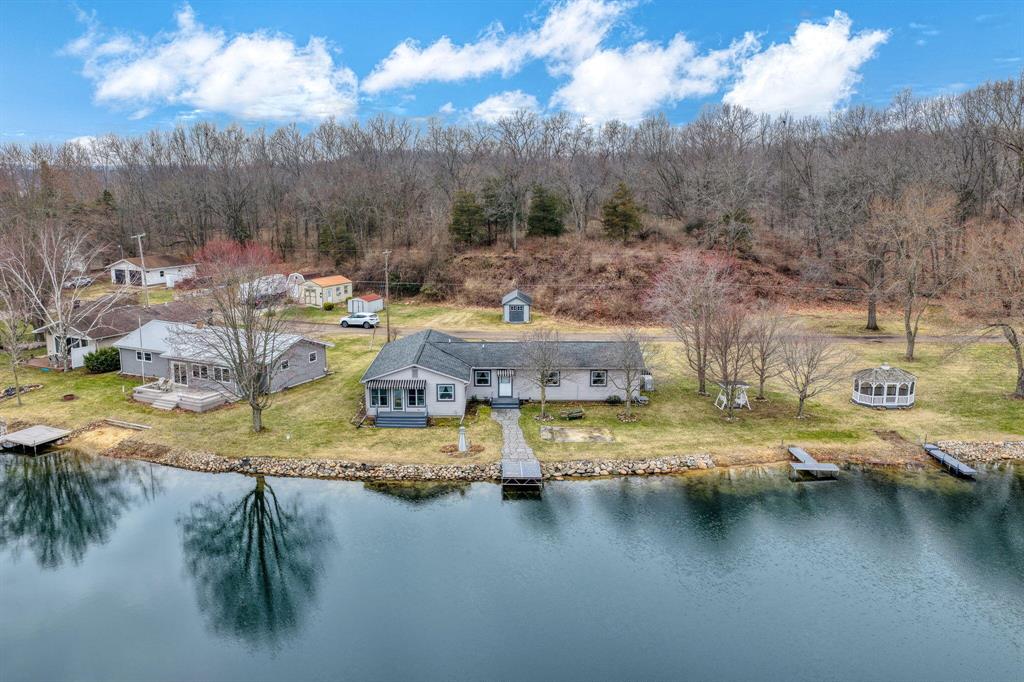 252 ft of private frontage on White Lake in the Irish Hills. This 3 bed, 2 bath ranch sits on 1 acre with additional lots across the street, offering rare space and flexibility. Enjoy a no-wake lake ideal for kayaking, fishing, and peaceful waterfront living. Expansive shoreline provides room for docks, entertaining, and future possibilities. Attached garage, storage shed, and screened porch complete the setting. A unique opportunity for lakefront living, weekend retreat, or investment property in a quiet natural setting.