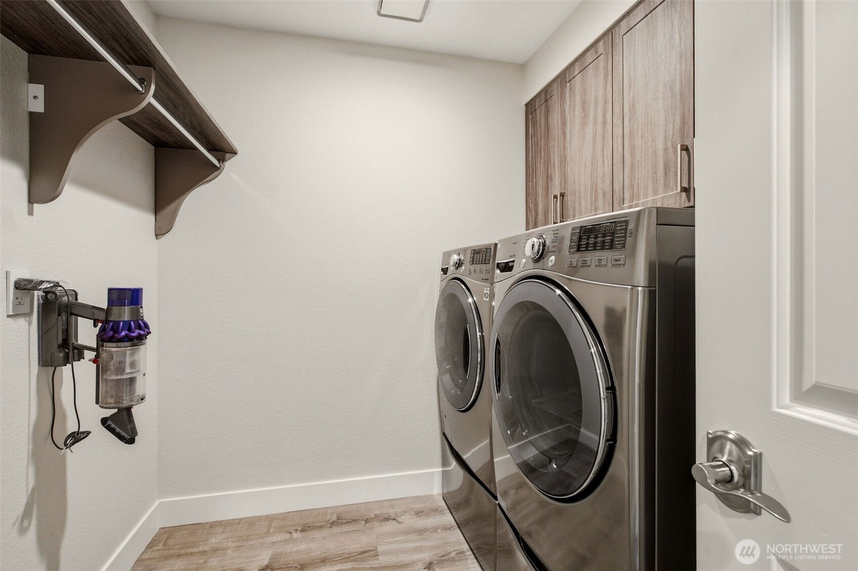 Dedicated laundry room with side-by-side washer, dryer, and extra storage.