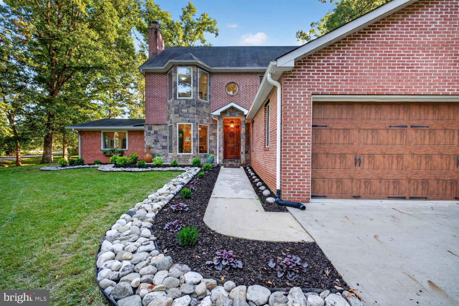 Tucked away among mature trees on nearly 0.8 acres, this home offers a rare sense of privacy and space that feels almost like country living, yet you are just minutes from the Springfield Mixing Bowl, shopping, dining, Metro, and major commuter routes. With 5 bedrooms, 5 full baths, 4,820 square feet across three finished levels, a three-car garage, and a fully fenced backyard, this home offers an incredible combination of space, setting, and convenience.Step inside to a dramatic two-story foyer with an open staircase, cascading pendant light, and a lighted built-in bookshelf near the entry. Wood floors extend throughout the main and upper levels, while the open and flexible floor plan provides plenty of room for everyday living, entertaining, working from home, and hosting overnight guests.The heart of the main level includes a welcoming family room with a gas fireplace, a separate dining room with double doors to the backyard, and a spacious kitchen with granite countertops and a window overlooking the property. One of the home's standout spaces is the large sunroom addition with a vaulted ceiling and walls of windows overlooking the trees. Gorgeous!Two bedrooms and two full baths are conveniently located on the main level, including one bedroom with its own en suite bath. This flexible layout is ideal for guests, multigenerational living, or anyone looking for true main-level bedroom space. A mudroom with built-in cabinetry and cubbies adds even more functionality.Upstairs, the spacious primary suite features a large walk-in closet and an en suite bath with a walk-in glass shower. Two additional bedrooms, one currently used as an office, and another full bath complete the upper level. The washer and dryer are conveniently located upstairs, with additional laundry hookups available in the basement.The walk-up lower level, with its own exterior stairwell entrance, adds even more living space with a large recreation room, a bonus room currently used as a gym, and an additional bonus room currently used as a bedroom, with a full bath. A utility and storage area provides plenty of room for everything you want tucked away.Outside is where the setting really shines. The large, flat backyard is surrounded by mature trees and enclosed with a low-maintenance Trex composite fence, creating a private retreat with plenty of room to play, entertain, garden, or simply enjoy the outdoors. A brick patio provides additional entertaining space, and a large storage shed offers added convenience.Parking is exceptional, with a three-car garage plus two separate driveways, one accessed from Oriole Avenue and another from Ridgeway Drive.Recent updates include a brand new water heater, refrigerator, dishwasher, and cooktop. A wall-mounted television in the basement and a second refrigerator in the garage also convey.All of this comes with NO HOA and an incredibly convenient location. Zoned for Garfield Elementary School, Key Middle School, and John R. Lewis High School.Enjoy the feeling of being tucked away in the trees while remaining just minutes from I-495, I-395, I-95, and the Franconia-Springfield Metro. Reagan National Airport and Washington, DC are within easy reach, amazingly only 20 minutes away, with Dulles International Airport 30 minutes away. Everyday conveniences including Whole Foods, Giant, Springfield Town Center, Target, Home Depot, and Inova HealthPlex are close by.Schedule your private showing today!