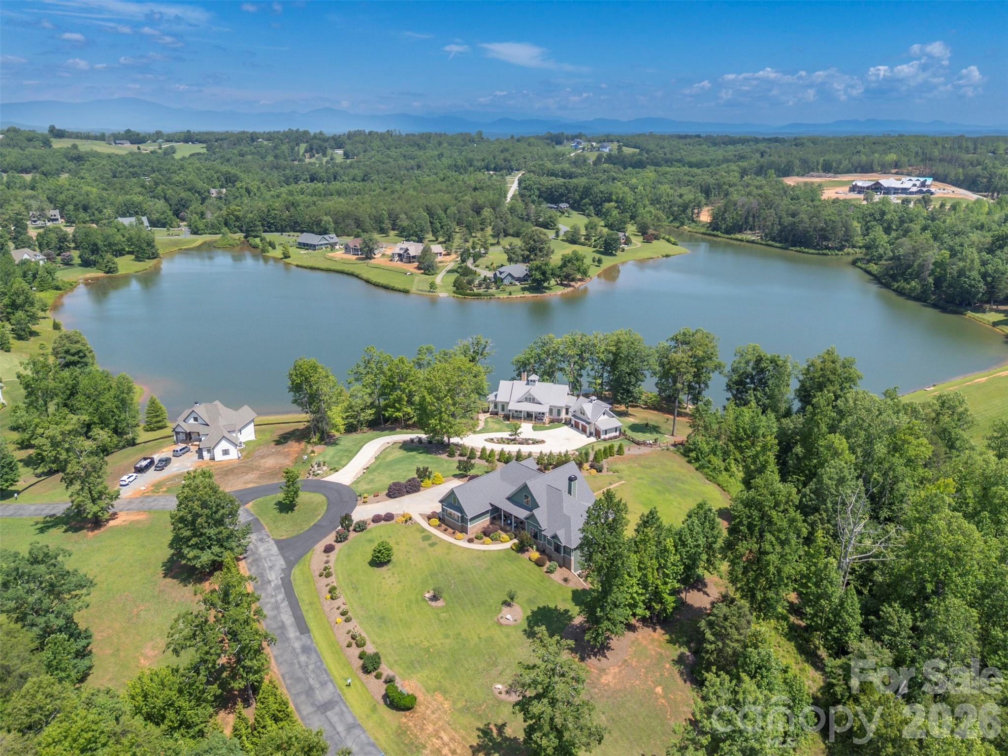 Welcome to your new home at "Derbyshire". Nestled in the rolling landscape of Columbus, North Carolina, Derbyshire is one of those places where life simply feels better.The gated community Derbyshire was designed with a lifestyle in mind, with deep equestrian roots, including a large community barn, a well-maintained riding arena, a round pen, multiple paddocks and pastures, hay storage, a tack room, and direct access to both the CETA and FETA trail systems. An ideal area, whether you own a horse (or two!) or just love the beauty of tree-lined streets and classically fenced pastures.At the center of Derbyshire sits Lake Sandy Plains, a 33-acre spring-fed lake. The lake views from your new home are breathtaking. Take a leisurely walk around the lake, fish, kayak, paddle board, canoe, and swim! Enjoy about 8 miles of walking trails around the community, or beautiful misty mornings and quiet sunsets. It won't take long to spot the "local" turtles basking on a log, the daily flights of a family of geese, and a lovely Blue Heron keeping a watchful eye on his kingdom. Your new home is set on an elevated 1.27-acre lot with the option to purchase the adjoining treed lot for additional space and privacy. This custom-built home was completed in 2020 by Mapleton Lane Custom Homes. This spacious home spans 5,314 square feet across three beautifully finished levels, offering space for hobbies, extended families, exercise, entertainment, and comfort. The main level, with its tall ceilings, offers 2,679 square feet of exceptional living space, centered on an open family room/dining/kitchen floor plan. The kitchen has a breakfast bar, a walk-in pantry, built-in features, and premium appliances. A dedicated home office provides a quiet retreat for work or reading, while the main-level laundry and mudroom add everyday practicality.The primary bedroom suite on the main level is a genuine sanctuary — nearly 284 square feet with two walk-in closets and a luxurious en-suite bath featuring a large shower and free-standing tub. At the other end of the home, on the main level, are two additional bedrooms that share a well-appointed full bath, making single-floor living entirely achievable for those who want it.Above the main level is a private 908-square-foot bedroom suite with its own full bath, ideal for family members returning home, long-term guests, a live-in caregiver, or even a creative studio retreat. It functions as a self-contained escape with its own sense of privacy and quiet. Downstairs, the walkout lower level adds 1,726 square feet of finished space, including a full bath, wet bar, ample storage, and flex space for an additional private living area, hobbies, a home gym, or whatever your imagination can conjure. And let's not forget the 390+ square feet of space, ideal for a workshop, with exterior access via an overhead garage door. Modern infrastructure completes the picture. Derbyshire is served by fiber optic internet, natural gas, municipal water, underground utilities, and underground power lines — meaning you enjoy the beauty and peace of mountain-adjacent country living without sacrificing a single convenience. Each floor has its own zoned heating and cooling, a whole-home approach to energy efficiency. This is not just a home. It's a way of living — unhurried, secure, beautiful, and only minutes from Landrum, SC, Tryon, and Columbus, NC. Derbyshire is only 20 minutes from Greenville and Spartanburg, SC, and 40 minutes from Asheville, NC. This peaceful jewel in the heart of horse country won't be available long...
