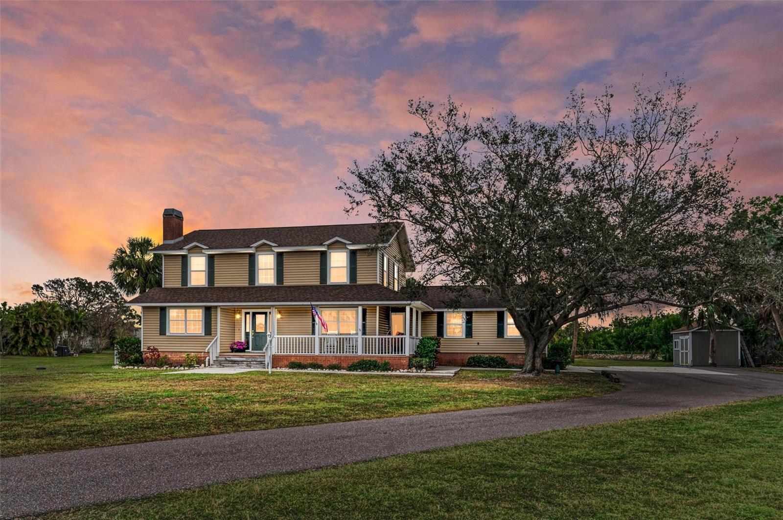 Welcome to this exceptional 4-bedroom, 2.5-bath home nestled in one of Palmetto’s most desirable neighborhoods! NO HOA or CDD, so bring your boats, trailers, campers, and toys with confidence. Situated on 1.35 acres with peaceful views of Lake Rowlett, this property offers the perfect blend of space, serenity, and convenience. As you arrive down the long driveway, you’ll be welcomed by a charming wraparound porch, ideal for rocking, porch swinging, and enjoying the Florida outdoors. The expansive front yard provides ample room for activities, gatherings, and family fun. Inside, the home offers a thoughtful layout with room for everyone, featuring a formal living room with a wood-burning fireplace and a family room. Entertaining is effortless with a seamless flow from the spacious kitchen, complete with wood cabinetry and granite countertops, into the formal dining room. A convenient half bath is also located downstairs, along with tile and vinyl plank flooring. Upstairs, you’ll find the master suite with ensuite bath, plus three generously sized bedrooms and a second full bathroom. The downstairs laundry room includes a sink, cabinets and the added bonus of a shower—perfect for rinsing off after pool time. Step outside to enjoy your sparkling heated pool and hot tub.  There is an abundance of deck space, offering endless possibilities for entertaining and relaxing. An outdoor shed provides additional storage, ideal for tools, equipment, or recreational gear. Embrace the lake lifestyle with opportunities to kayak, fish, and observe Florida wildlife right from your own backyard. Recent updates include fresh interior paint, a new roof in 2023, and a newer pool pump/heater. Ideally located with quick access to St. Pete, Tampa, Sarasota, beaches, shopping, and I-275/I-75, this home truly has it all. Don’t miss this rare opportunity—schedule your showing today!