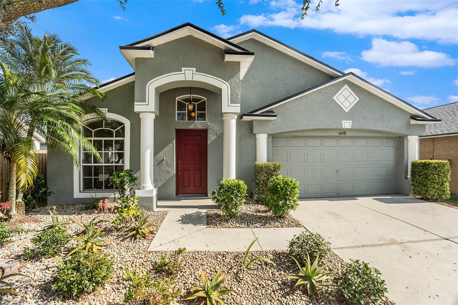 Step into this beautiful 3-bedroom, 2-bath home offering 1,440 sq ft of stylish, low-maintenance living. The freshly painted interior—doors, baseboards, and ceilings included—creates a clean, modern feel from the moment you enter.You’ll love the tall ceilings, open kitchen, and modern gray cabinetry, complemented by a stainless steel refrigerator and brand-new waterproof laminate flooring that flows seamlessly throughout the home. Enjoy peace of mind with a 2023 roof and 2017 A/C, plus a fully fenced backyard perfect for pets, play, or outdoor entertaining. A welcoming living and dining room greet you upon entry, enhanced by vaulted ceilings that create an open, airy feel. From there, flow seamlessly into the open kitchen, which offers space for a small bistro table or additional pantry storage. Access the laundry room and 2-car garage directly from the kitchen, or continue into the family room at the heart of the home. Sliding glass doors lead to the spacious backyard, and the split bedroom floorplan provides added privacy, with a long walk-in closet in the primary suite. Located in a low-fee HOA community in the heart of Wesley Chapel, this home is just minutes from popular shopping, dining, and great restaurants. Many updates are already complete, with just enough opportunity left for your personal touch to finish the home to your taste. A wonderful blend of comfort, style, and potential...ready to make your vision a reality.