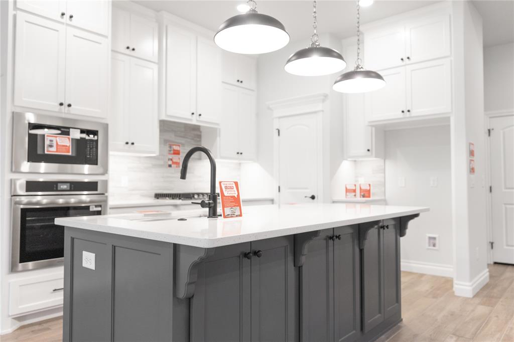 FENCING AND BLINDS INCLUDED! This Hummingbird floor plan features 2,025 Sqft of total living space, which includes 1,800 Sqft of indoor space and 225 Sqft of outdoor living. There is a 565 Sqft, three car garage with an in-ground storm shelter installed. This home offers 4 bedrooms, 2 bathrooms, 2 covered patios, and a large utility room. The great room welcomes a breathtaking cathedral ceiling, a gas fireplace with our stacked stone surround detailing, large windows, rocker switches throughout, wood-look tile, and Cat6 wiring. The high-end kitchen has 3 CM countertops, custom-built cabinets to the ceiling with cabinet hardware installed throughout and under cabinet lighting, stainless steel appliances, a 5-burner cooktop, vogue tile backsplash, stellar pendant lighting, a corner walk-in pantry, and a large center island equipped with a trash can pullout, sink, and dishwasher. The elegant primary suite has a sloped ceiling detail with a ceiling fan, windows, Cat6 wiring, and our cozy carpet finish. The attached spa-like bath includes a dual sink vanity with framed mirrors, TWO spacious walk-in closets, a roomy European walk-in shower, and a free-standing tub. Secondary bedrooms feature high ceilings with ceiling fans, windows, spacious closets, and carpeted flooring. The covered back patio offers a wood burning fireplace, a TV hookup, and a gas line for your grill. Other amenities include Healthy Home Technology, a fresh air ventilation system, a tankless water heater, R-44 insulation, and more!