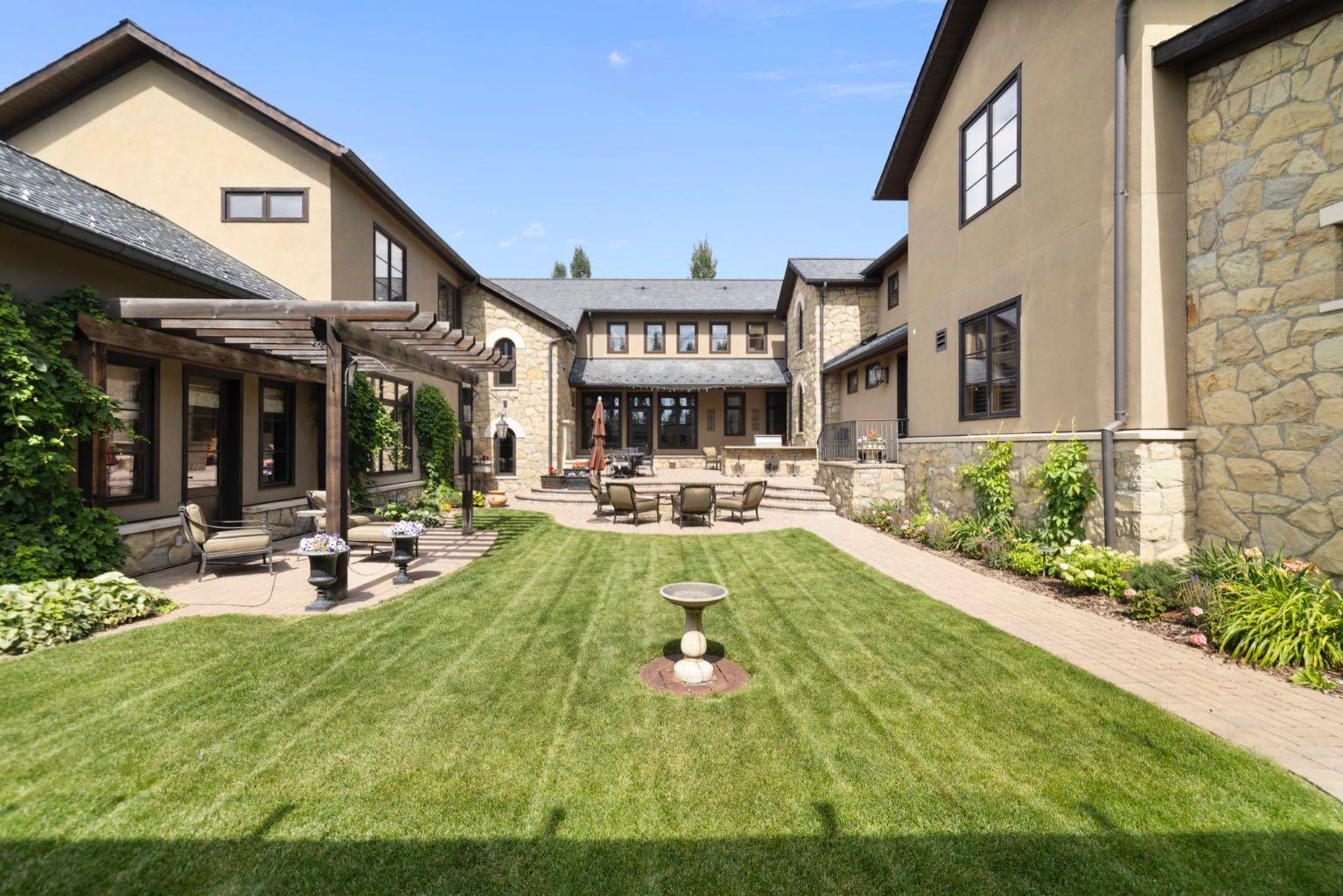 Stampede Special! Welcome to 209 Pinnacle Ridge, an exceptional Tuscan inspired estate set on two acres in the foothills with sweeping views of the Rocky Mountains and just minutes from Calgary’s finest amenities. With more than 16,000 square feet of living space, this villa combines timeless European charm with modern luxury in every detail.The exterior showcases stonework, hand sawn timber beams, industrial steel brackets, and an oversized custom entry door. Inside, arched doorways, barrel vaulted ceilings, and perfectly aligned sightlines frame picturesque views throughout.The grand foyer with its soaring ceiling and bridge walkway leads to a formal lounge with paneled walls, coffered ceilings, and a wood burning fireplace. At the heart of the home, a gourmet kitchen with slab marble islands and a full suite of commercial grade appliances opens to the central courtyard, a private gathering space with built in BBQ, wall fountain, and pergola topped brick patio. Just beyond, the family room features a travertine mantled fireplace and French doors to the west lawn.The lower level is designed for both leisure and entertainment, offering a 25-meter lap pool, spa inspired hot tub alcove, walkout patio framed by sandstone boulders, a private theatre with professional grade audio visual, a games room with fabric lined walls, and a brick barrel vaulted wine cellar.The private primary wing showcases sweeping 180 degree mountain views and a luxurious ensuite. The upper level, accessed by dual staircases or elevator, offers five children’s bedrooms, a gym, and recreation spaces. Completing the home is a six car garage, extensive storage, a sport court, and professionally landscaped grounds. All furniture and décor, excluding the piano, is now included in the purchase price.This estate has been featured in the National Post and Best Home Alberta, showcased in the award-winning series Fargo, and even served as Leonardo DiCaprio’s residence during the filming of The Revenant. It is a rare combination of artisanal craftsmanship, imported and local materials, and timeless architectural design. All within 10 minutes of Springbank Airport, 15 minutes of downtown Calgary, 40 minutes to Banff, and close to Calgary’s top private schools.