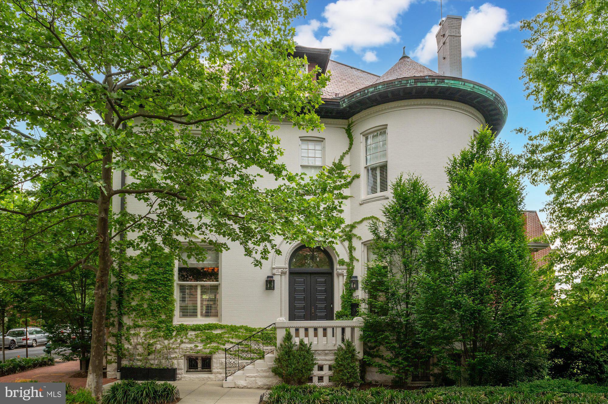 Welcome to 1823 Phelps Pl NW, a distinguished residence in the heart of Kalorama, one of Washington, D.C.’s most prestigious neighborhoods. This architectural masterpiece was built in 1905 in the Romanesque Revival style of pre-eminent American architect Henry Hobson Richardson. It is historically significant as having been built for the president of the Lincoln National Bank. Blending historic grandeur with modern luxury, the home offers an exceptional setting for both elegant entertaining and comfortable living. The striking entry vestibule leads to a foyer adorned with original paneling and a coffered ceiling. Sun-drenched living spaces feature soaring 11’+ ceilings, exquisite moldings and restored pocket doors. The chef’s kitchen boasts a large center island, high-end Sub-Zero, Viking and Bosch appliances, and a sunlit breakfast room with French doors to the terrace. There is also a sophisticated family room (or second formal living room) with a dramatic marble fireplace surround and built ins. The rooms flow seamlessly into the elegant, large dining room. A stunning powder room and three gas fireplaces complete the main level. The elevator serves all four levels of the house.  The second level hosts the expansive owner’s suite with a gas fireplace, spa-like Waterworks marble bath, large walk-in closet, and an extraordinary second closet/ room-sized dressing room with custom built-ins and a beverage center. Two additional en-suite bedrooms and a laundry room provide convenience and comfort on this level. The third level is a stunning retreat, featuring the fourth and fifth bedrooms, two full baths, a sitting room, and a bonus room that could be a private office or a playroom. The skylight provides light from above, down to the main level. The lower level of the house offers an array of lifestyle amenities, including a media room, full-size gym, in-law suite with separate entrance and full bath, temperature-controlled wine cellar, powder room, and access to the two-car garage with ample storage. The private garden is an entertainer’s paradise, featuring a dining area, fire pit, built-in grill station, pergola, fountain, and lush landscaping.  Kalorama is graced by various notable homes and embassies and ideally located close to the Dupont and Woodley red line Metro stops, the famed Sunday Dupont Farmers Market, The Phillips Collection, a myriad of restaurants, shops, cafés, and galleries, and other conveniences. Rock Creek Park is also just a few blocks away on foot or via car.
