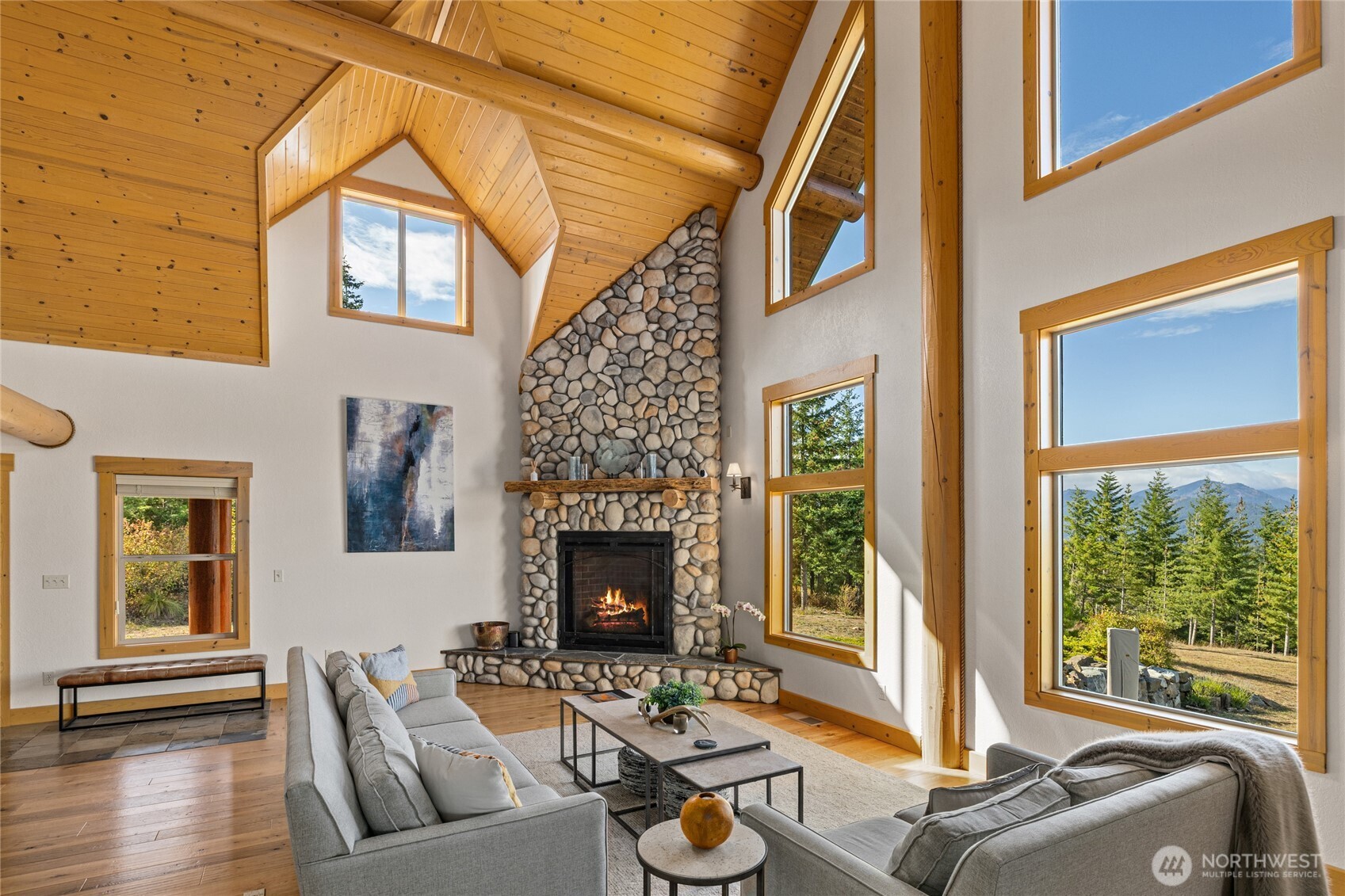 Oversized windows bring the landscape into the great room while highlighting the home’s impressive vaulted architecture and natural wood details.