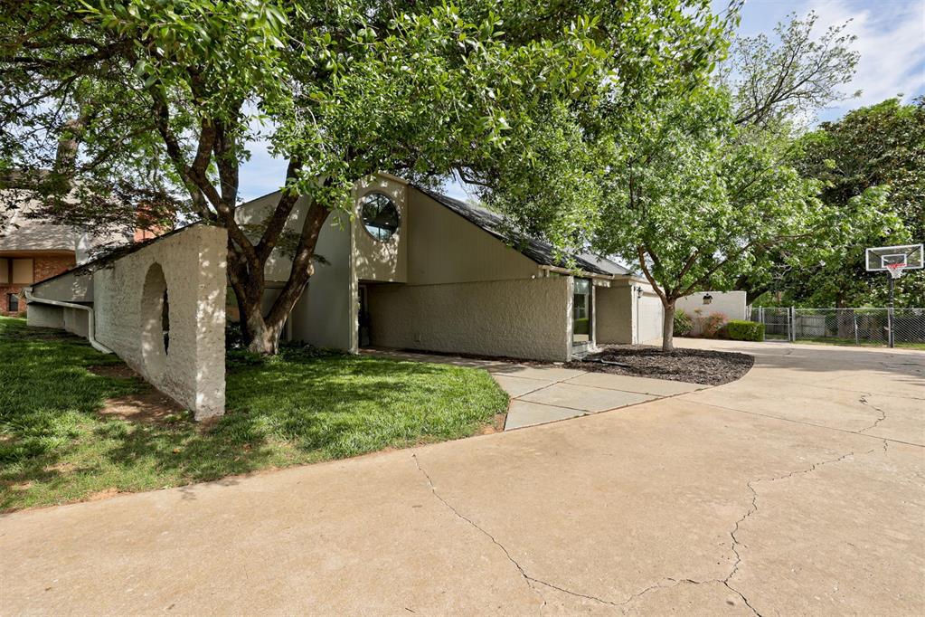 A REMARKABLE HOME NOW AT AN EVEN MORE COMPELLING PRICE! Tucked beneath a canopy of mature oaks and Japanese maples in Rustic Hills—a hidden, one-street enclave just blocks from the University of Oklahoma—this contemporary home delivers architecture, privacy, and presence. Natural light floods every corner through intentional window placement, while sliding doors and multiple patios create seamless indoor-outdoor living.Inside, you’ll find soaring ceilings, a striking floating staircase, and a wall of windows that makes the living space feel alive. The kitchen is both beautiful and functional with granite counters, modern finishes, a wet bar, and a massive walk-in pantry. Just beyond, the breakfast area offers a quiet moment to start the day. In addition to the main living spaces, the downstairs includes two spacious bedrooms with a Jack-and-Jill bath, plus a versatile flex space with a built-in Murphy bed—ready to adapt to your lifestyle. Also concealed down the main hallway - the chic powder bath and downstairs laundry room. Upstairs, the primary suite is its own private escape—complete with a sitting area, beautifully appointed spa-like bath, generous walk-in closet, and in-suite laundry. Statement windows frame the sky and surrounding tree canopies, bringing the outdoors in. And while the design is undeniably eye-catching, the behind-the-scenes updates matter just as much—featuring newer HVAC systems, hot water tanks, and an updated electrical panel for peace of mind. Multiple patios and sliding doors continue the indoor-outdoor experience, all set beneath a canopy of mature trees. Zoned to Monroe Elementary with quick access to Highway 9, OU, and Norman amenities—this home offers a rare blend of design, function, and location. This is the one for buyers who truly want something different.
