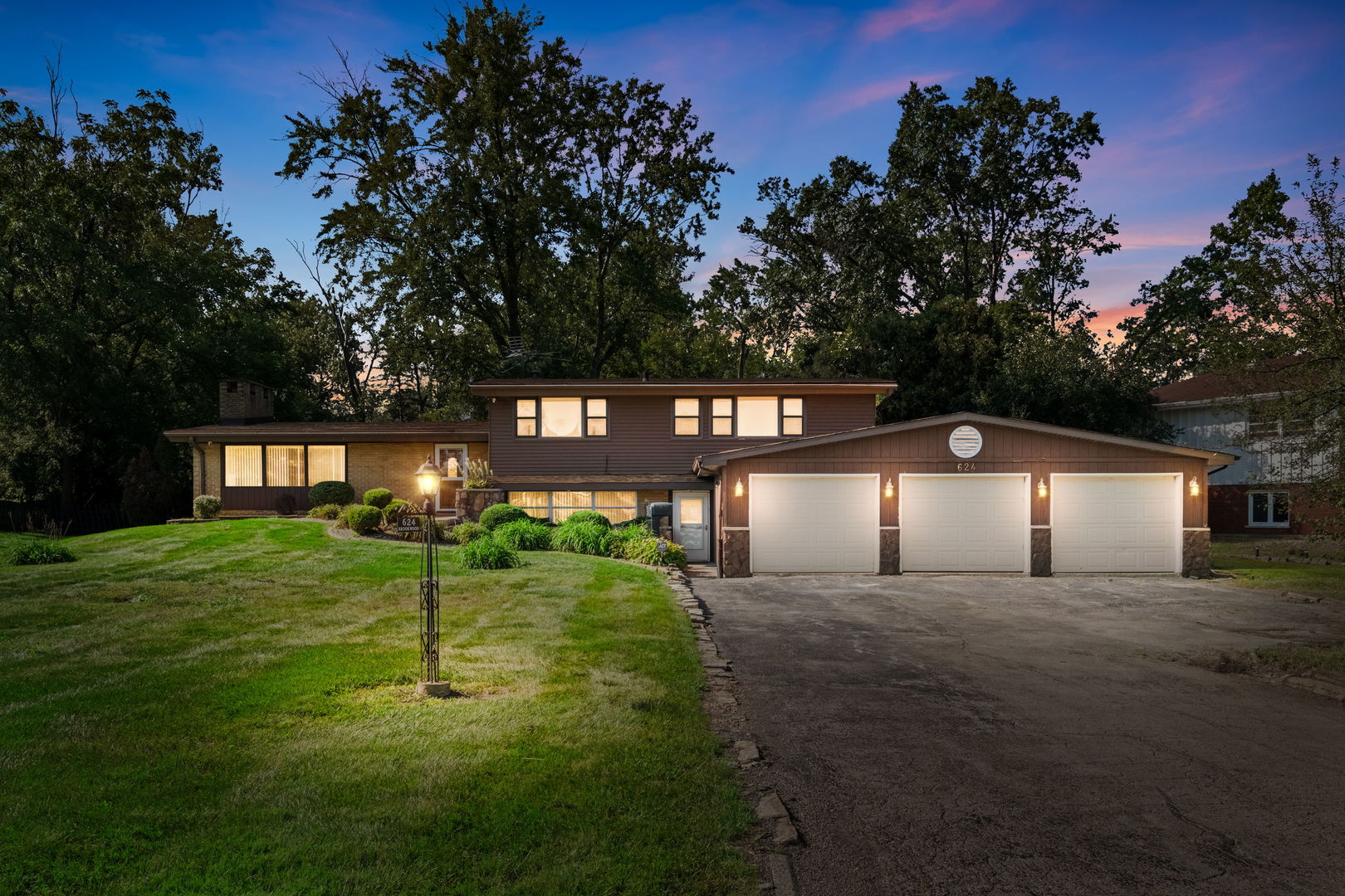 Welcome to 624 Brookwood Terrace, a beautifully updated 3,199-square-foot split-level home in Olympia Fields offering the perfect blend of mid-century architectural elegance and modern luxury. Nestled on a sprawling, private half-acre lot framed by mature trees, this spacious 4-bedroom, 2.5-bathroom residence features 9 oversized rooms designed for effortless daily living and large-scale entertaining. Step inside to discover a light-filled floor plan enhanced by dual eastern and western exposures, soaring vaulted ceilings anchored by exposed dark wood beams, rich brick accents, and a welcoming brick paver entry. The main living room serves as a dramatic centerpiece with its whitewashed brick fireplace and floor-to-ceiling panoramic windows overlooking the front lawn. The fully updated gourmet eat-in kitchen is a chef's dream, showcasing custom espresso cabinetry, a floor-to-ceiling pantry unit, thick granite countertops, a glass tile backsplash, and wood-look tile flooring. Premium Energy Star stainless steel appliances include a gas range, double oven, dishwasher, double refrigerator, and an oversized apron-front farmhouse sink set beneath a bright picture window, complemented by an extended counter peninsula with breakfast bar seating. On the grade level, dedicated family and recreation rooms provide ideal flexible space for a home theater or lounge, complete with sliding glass doors opening directly to the rear patio. Upstairs, four generous bedrooms offer rich hardwood floors, ample closet space, and serene natural views. The primary bedroom features a custom-organized closet and an updated full ensuite bathroom with a windowed layout and separate shower, while all bathrooms throughout the home have been tastefully modernized. Enjoy year-round comfort with central air conditioning and forced air heating. Outside, the extensive grounds offer complete privacy and room for outdoor activities, while vehicle and equipment storage is effortlessly handled by an attached 3-car garage and an oversized asphalt driveway with room for multiple cars, an RV, or a boat. Perfectly located just minutes from Olympia Fields Country Club, Flossmoor Country Club, four neighborhood parks, top-rated schools, and prime shopping and dining, this turnkey home offers exceptional quality and convenience. Make 624 Brookwood Terrace your new home and schedule your private tour today!