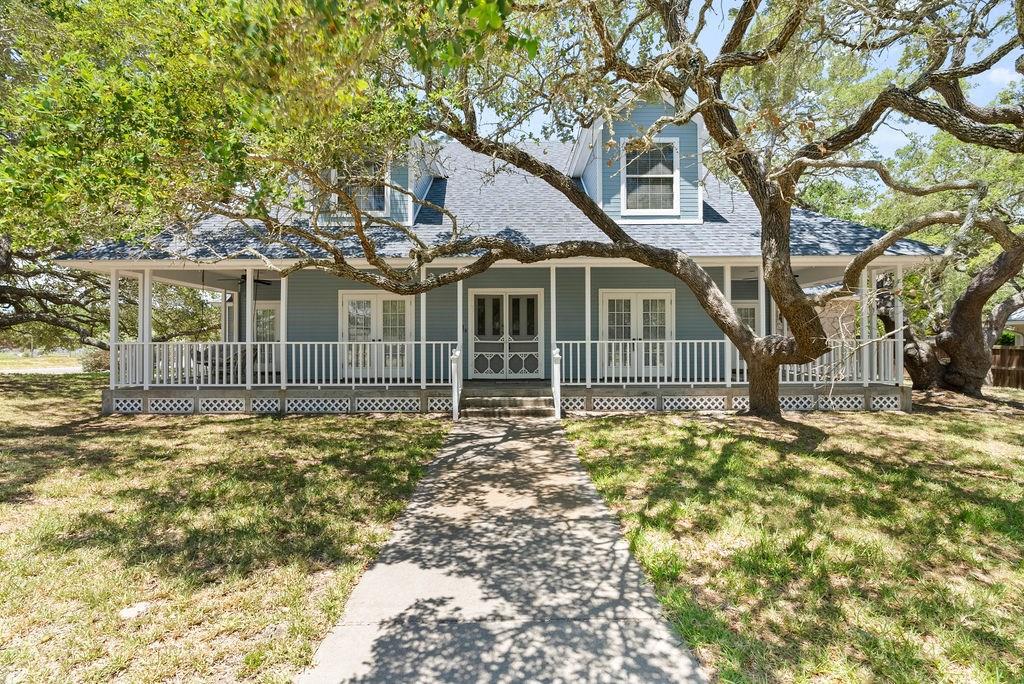 Take another look at this gorgeous home. Freshly painted exterior a and new price! Welcome to 2500 Turkey Neck Circle, a Victorian Country-style gem nestled on a peaceful corner lot in Rockport, Texas. This enchanting home offers a spacious living room with a charming fireplace, a formal dining room, a sun-drenched sunroom, and a cozy reading room—perfect for all your leisure activities. The elegant covered porch invites you to relax. I can just see the fall decor or a cozy swing. A detached two-car garage provides ample space for your vehicles and storage needs, while a deeded boat slip enhances your waterfront lifestyle. Experience the perfect blend of classic charm and perfect location in this serene retreat.