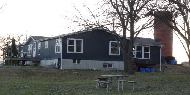 19.3 Acres on Blacktop 1/2 mile from I 49. Look what this property has to offer. (2 Homes) 3 BR Manufactured home on a full concrete bsmt./ 4 egress windows. Bsmt has a sump pump but is not needed. Sun Room/Family Rm/Mud Rm/Office/Sports Rm is first room coming in from large concrete parking. This rm has great views of the property & open 4' wide stairs to bsmt. Home comes/all appliances even the washer & dryer. Cozy Breakfast Rm has views of the back side of the property. Dining Rm or could be another living space off the kitchen/pass through bar. New LVP in Family Room and laundry area. Laundry Area has 3 closets for storage. Sun Room has a walk-in Pantry or Storage Room & Coat Storage. Master BR bath has tub & a ceramic tile walk-in shower. Bsmt is ready for you to finish/ more bedrooms (Egress Windows in place) or more living space. It is dry but has a sump pump just in case. Outside is an older 1920's barn with silo. a 45'x80' Machine Shed / its own breaker box & Freeze Proof water hydrant. At one time it was set up for animals. Chicken house, 2nd storage building. ADDITIONAL 2 BR house/CH & CA, separate septic, electric meter & propane tank.  Great Parents-In-Law Quarters. or rent out for extra income. Property is fenced, cross fenced, 2 ponds, rich soil hay fields, lagoon for house. Deck on back side, NEW Pool, 30x30 treated wood Deck, Tiki Bar (read the disclosure for pool==lots of new updates. Property sets close to I 49 and would have the advantage if someone wanted to turn the older barn into a business. Use the 45x80 Machine Shed for camper or boat storage, or raise chickens, goats or cattle. Enough room for the kids horses and enough flat ground for an arena. Walnut & Pecan trees, lg blackberry patch.  If you like to live/ a view, close to the Main Highway, close to town take time to come visit this retreat. Heat Pump/ Emergency Propane Gas Backup. Very inexpensive heating and cooling bills. New outside Paint 2025. Less than 1 hour south of Kansas City