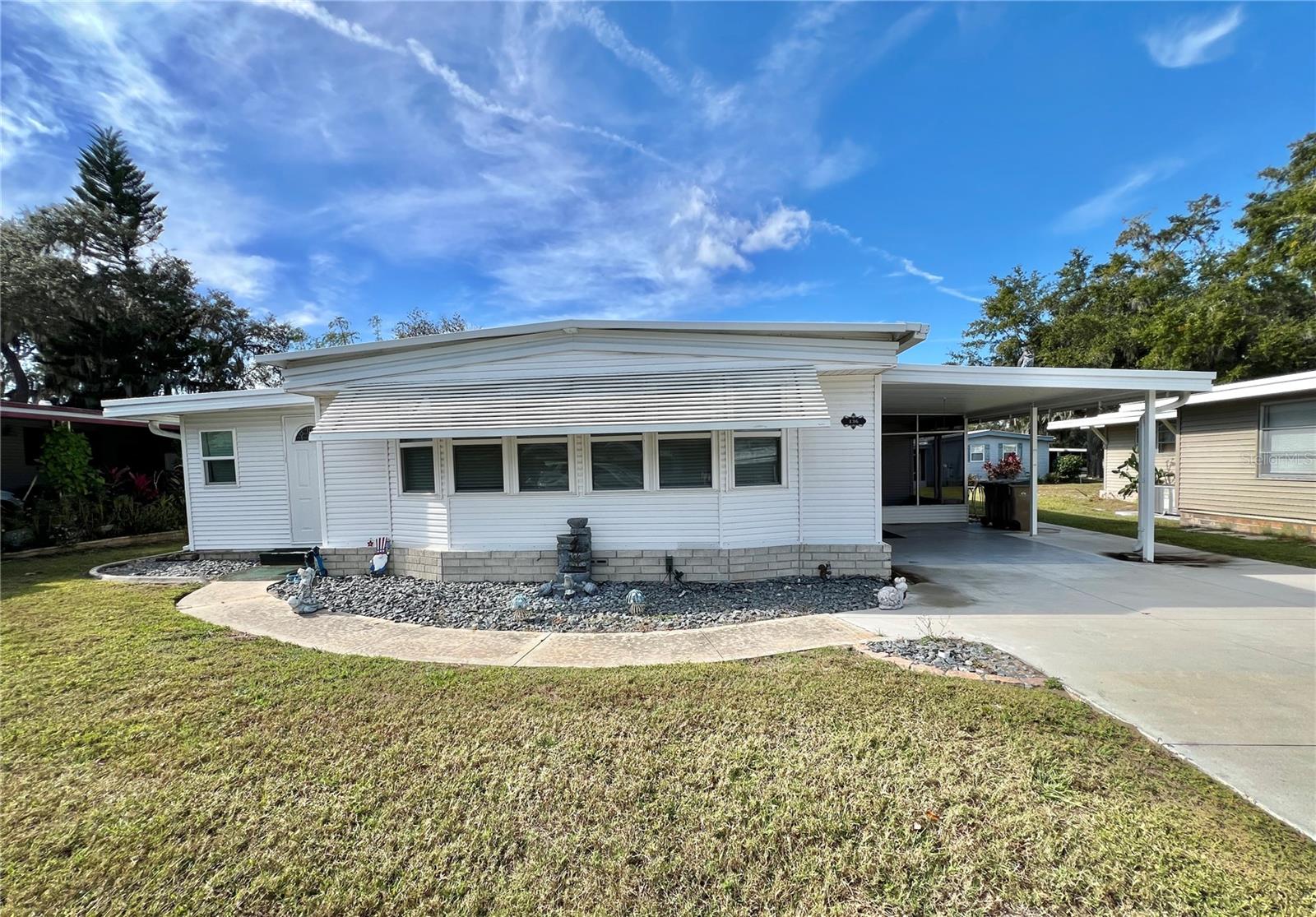 Spacious and inviting, this furnished exceptionally updated 2-bedroom, 2-bath home offers 1,332 sq. ft. of comfortable living in the desirable Aspen Circle community. The home features a roof-over completed in 2005, vinyl siding added in 2004, and a wide double driveway that provides plenty of parking.Step inside to find vinyl plank flooring installed in 2020, creating a clean and cohesive look throughout. The home includes an enclosed screen room, large laundry, utility room, and the beautiful Florida room is a standout feature, designed for both relaxation and entertaining, and enhanced with a stylish quartz countertop that adds function and flexibility for a sitting area, office, or hobby room.The kitchen is thoughtfully upgraded with ample cabinetry, upgraded appliances, quartz countertops, decorative backsplash, pendant lighting, and generous storage, making it as practical as it is attractive. Both bathrooms have been refreshed with updated vanities, fixtures and countertops, providing a clean, modern feel.This well-cared-for home blends space, comfort, and quality updates in a peaceful setting, perfect for full-time living, seasonal enjoyment, or an easy Florida lifestyle............Hawthorne at Leesburg is an active, resident owned, 55+ cooperative, waterfront, gated community, with beautifully landscaped grounds, lakes with illuminated fountains and a relaxing and comfortable gazebo. The affordable monthly maintenance fee of $397 includes water, sewer, lawn mowing, private emergency services and storage space for recreational vehicles, boats, trailers and much more! The beautiful clubhouse is complete with a full-time program coordinator, more than 100 different activities and seating for 550. It has a hospitality lounge, card rooms, craft rooms, billiard room, fitness center, library, fine arts room and many more. There is excellent fishing, outdoor geo-thermally heated pool and two enclosed therapeutic pools. Hawthorne boasts a private marina monitored by an electronic security system with over 120 boat slips and access to the Harris Chain of Lakes and beyond.