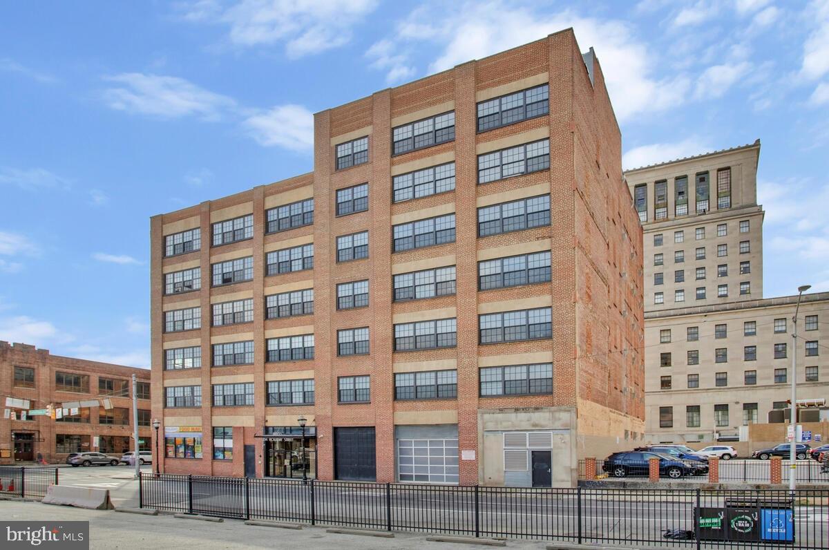 Discover a condo unlike any other in the heart of Downtown Baltimore—a dramatic fusion of design, technology, and luxury living. This 2-bedroom residence with dual primary suites isn’t just smart, it’s brilliantly intuitive. Imagine programming your shower’s temperature and lighting before you even open your front door, or walking into music, climate, and ambiance already set to your preferences. Brilliant Smart Home controls and an integrated Sonos system create a seamless experience throughout, while floor-to-ceiling windows frame breathtaking views of Baltimore City Hall. Every detail has been elevated: custom barn doors, waterproof laminate flooring, a built-in laundry center, and sleek new Samsung appliances. Both ensuite baths are spa-level retreats with smart bidet toilets, heated floor in one bathroom, custom lighting, and a fully reimagined Onsen-inspired wet bath with Moen automated shower and ceiling-fill garden tub. Industrial chic finishes—exposed concrete, refinished pipes, and preserved brick—blend with modern touches like custom closets, smart blinds, a gel fuel fireplace, and upgraded air systems. And for the ultimate convenience, a deeded garage space big enough for two cars with Level 2 EV charger awaits. This is more than a condo—it’s a lifestyle, engineered for the future.