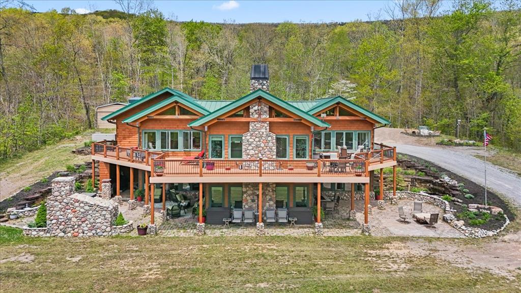 Escape to your own private mountain oasis nestled among breathtaking natural beauty. This stunning owner-designed, custom built, cedar shake and stone siding home blends rustic charm with timeless luxury, offering the perfect retreat for peaceful living and unforgettable entertaining. Only the best local master craftsmen were used to build this custom home. Perfectly placed on 100 wooded acres this beautifully crafted home, in a gated community, features elegant stone accents, and inviting outdoor spaces that seamlessly connect with nature. Inside you will find spacious living areas filled with natural light, soaring ceilings, cozy fireplaces, and upscale quality finishes throughout. Enjoy mornings on the deck breathing fresh mountain air and evenings by the firepit under the stars. Whether you are seeking a full-time residence, vacation get away, or investment property, this home delivers quality, comfort and character. The interior of this home is unmatched! Offering light hickory flooring, large gourmet kitchen and open concept living. There is an abundance of extra storage and closet space. Expansive decking and outdoor living spaces offer endless entertainment opportunities, featuring a stunning stone fireplace. The property boasts of two well-designed, heated garages. One is 26 x 40 and the other is 50 x 25. If you are a car collector, in need of storage for your recreational vehicles, or a hobbyist needing a quality workspace then you have hit the jackpot! There's even a spot for a helicopter landing pad on this massive property! Bottom line, it is truly difficult to describe what this secluded mountain estate has to offer, so come see for yourself!