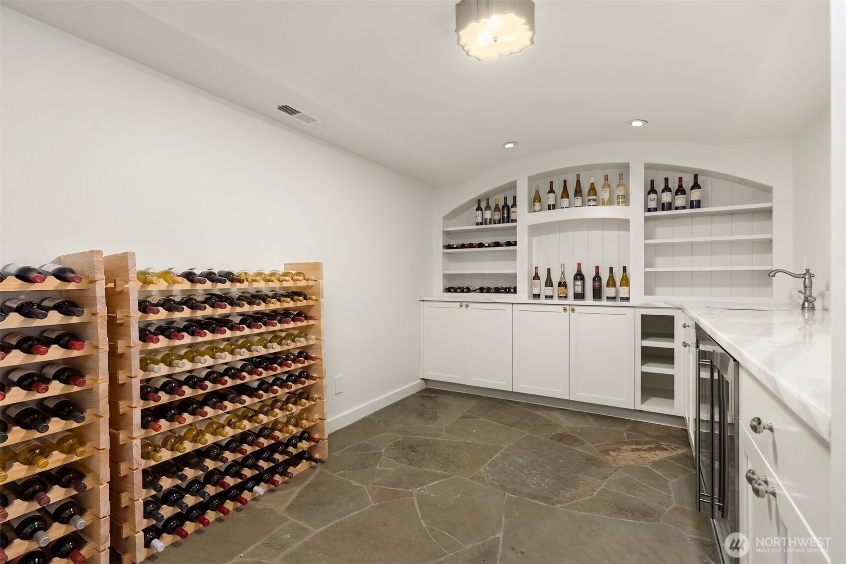 Impressive wine cellar featuring custom storage and a stone floor.
