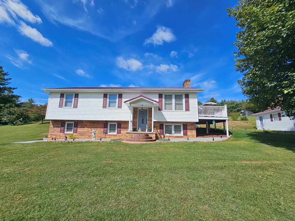 Located just outside the charming Town of Independence, this beautifully maintained split foyer home offers both space and comfort in a peaceful setting. The main level features a spacious and spotless interior with three generously sized bedrooms and 1.5 baths. A cozy brick fireplace with a wood stove insert creates a warm focal point in the living room, while the kitchen boasts oak cabinets, Corian countertops, a stylish tile backsplash, and all major appliances included. Downstairs, you'll find a large den perfect for relaxing or entertaining, an additional bedroom with its own wood stove, a full bath, office space, and a dedicated laundry area. Step outside onto the large deck with low-maintenance vinyl railing and Trex decking — ideal for gatherings or quiet evenings. The home is finished with vinyl siding, a durable metal roof, and includes a two-car detached garage and a paved driveway. All this, just minutes from the scenic New River, offering a nice blend of comfort, convenience, and natural beauty. Call Today!