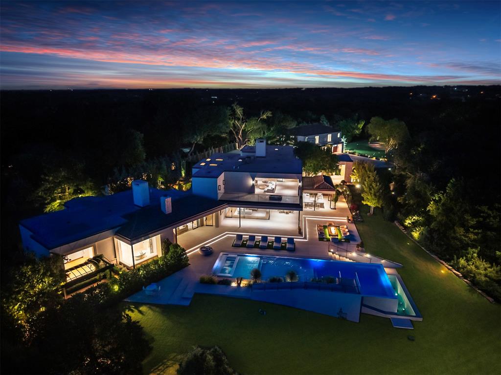This is not the Hollywood Hills. Panoramic OKC views stretching straight to the downtown skyline, this new estate has the same hillside drama, the same sense of arrival, and price tag to match, without ever leaving Oklahoma. No expense was spared in building this one-of-a-kind residence. Over $14,000,000 invested. This luxury masterpiece rises behind a private gated entry within its own gated community, its glass exterior walls catching the Oklahoma sky from nearly every room. Vaulted ceilings soar overhead while imported hardwood French floors run underfoot, and four fireplaces bring warmth to the home's most gathered spaces. A dedicated office and den offer quiet retreat, while a bonus and game room keeps the estate lively for family and guests alike, and four separate laundry rooms mean the home runs as efficiently as it entertains.The primary suite is a study in indulgence, anchored by his and hers closets, while a private guest apartment ensures visiting family or staff enjoy the same level of comfort as the main residence. Culinary life centers on a chef's kitchen fitted with a La Cornue gas range and the home's six-car garage, split between attached and detached spaces with an additional carport, gives every car collector room to breathe.Outside, the estate becomes a resort in its own right. A swimming pool and hot tub anchor an outdoor living area built around a fire pit, an outdoor kitchen, and a full wet bar, all framed by extensive professional landscaping. Other amenities include: home gym, game/bonus room, commercial generator, guest apartment, extensive landscaping, wall to ceiling glass walls, electric shades, his & hers closets, gated entry & separate service gate, etc. Set on a quiet cul-de-sac within a gated community. This estate offers what few properties in Oklahoma, or anywhere, can claim: the scale, the skyline of Hollywood, built and priced for Oklahoma City. Surrounded by almost 100 wooded acres of peace and quiet.