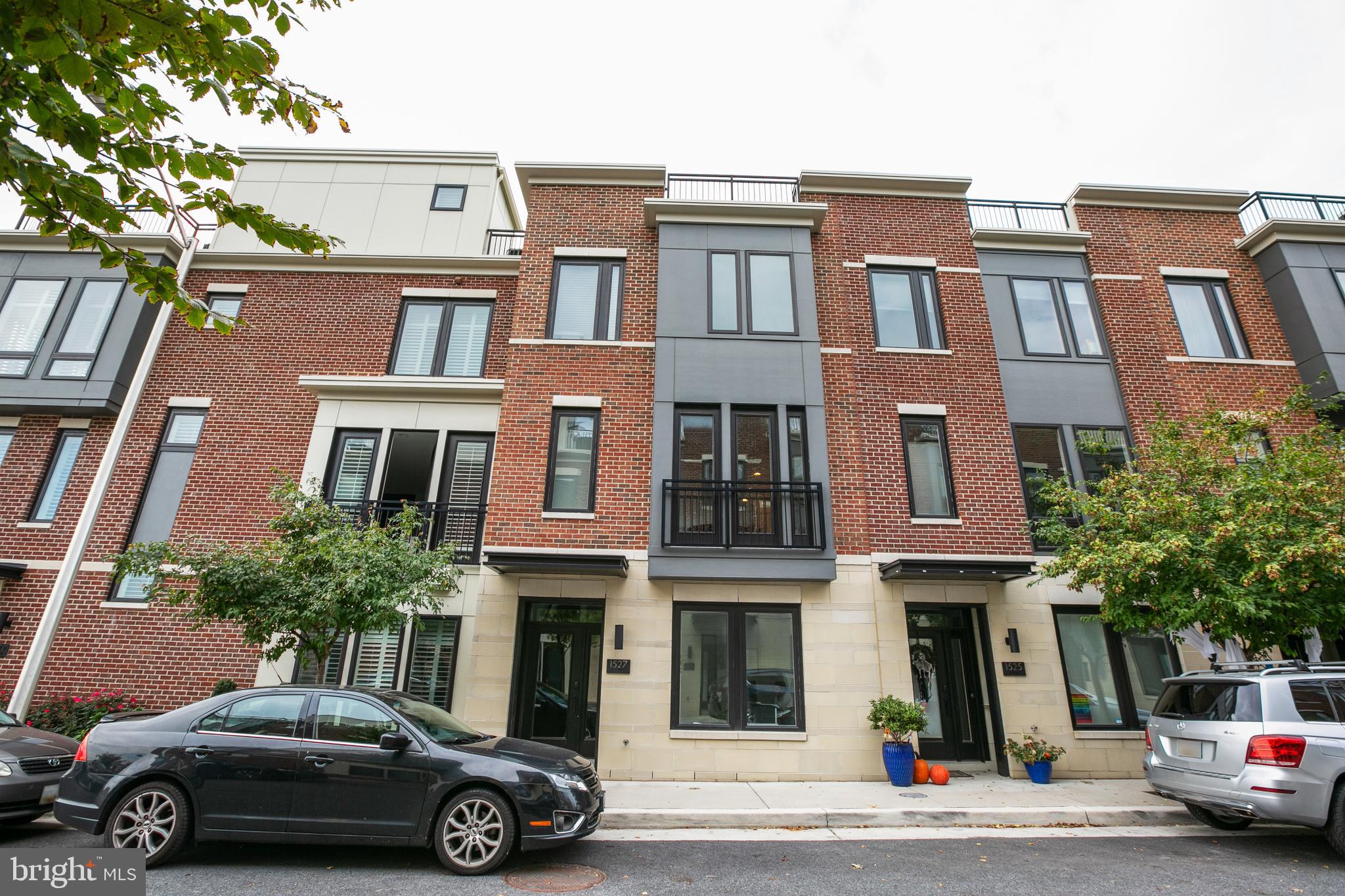 Welcome to unparalleled luxury living in the heart of Locust Point. Nestled within the highly coveted Alta 47 community and masterfully crafted by Bozzuto, this newly constructed, three-bedroom, 3.5-bathroom townhome offers a sophisticated urban sanctuary designed for the modern connoisseur. From the moment you step inside, the home commands attention with its "production-grade" aesthetic, boasting high-end architectural details, striking custom flooring, and an abundance of natural light that has served as the backdrop for professional commercial shoots. The heart of the home features a pristine, all-white gourmet kitchen outfitted with upgraded cabinetry, exquisite quartz countertops, and a premium suite of smart appliances including a state-of-the-art refrigerator that allows you to view its contents from your phone, stream your favorite shows, and play music seamlessly.Designed with absolute comfort in mind, the residence features two lavish primary suites, each accompanied by massive, custom walk-in closets and spa-like en-suite bathrooms. The property is a triumph of smart-home integration, entirely automated via Alexa. With the touch of a button or a simple voice command, you can effortlessly control the home's custom lighting and automatic window treatments, which include premium blackout shades in all bedrooms for ultimate privacy and rest. The tech-forward design continues behind the scenes with a high-efficiency tankless water heater, integrated built-in speakers wired throughout the entire interior, and a spacious two-car garage providing rare and secure urban parking.The crown jewel of this exceptional property is the massive, full-footprint rooftop deck, an entertainer's paradise that spans the entire width of the home. Engineered for year-round luxury, the rooftop features integrated rough-ins for a wet bar and gas grill, creating the ultimate canvas for al fresco dining. The highlight of this outdoor oasis is a custom-engineered, motorized garage door that lowers to completely protect the rooftop wet bar area and a 65-inch television from the elements. Whether you are hosting high-profile gatherings against the backdrop of the city skyline or enjoying a quiet evening wired with premium sound, this Locust Point masterpiece offers an unmatched rental opportunity for those who demand the very best.
