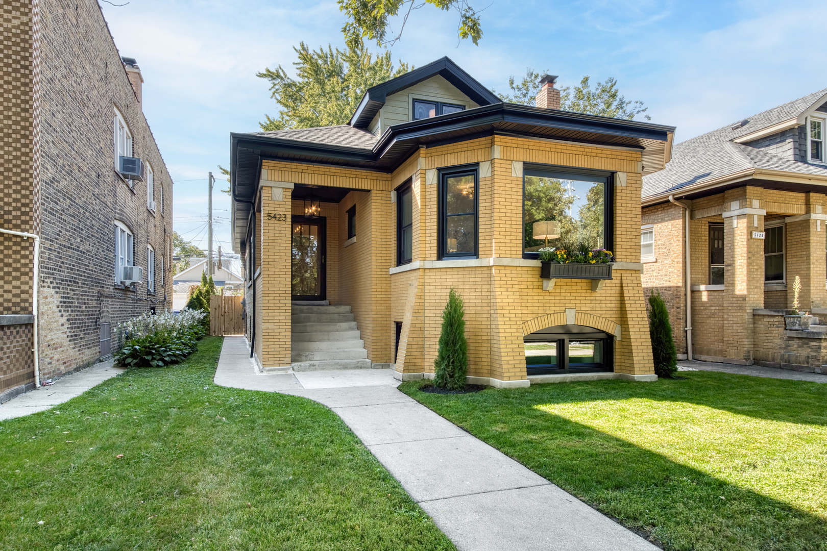 Across from idyllic Chopin Park on tree-lined Roscoe Street, this exquisitely rehabbed yellow brick bungalow blends timeless character with modern design. Behind its classic facade awaits a spacious, light-filled home offering 5 bedrooms and 3 full baths.    Thoughtful craftsmanship and quality finishes, are the key mark for this experienced builder.   The main level showcases a gracious living room with wood-burning fireplace, formal dining room and bay window, two bedrooms, a full bath, and a crisp white kitchen that opens to a sunny breakfast nook/family room. Sliding doors lead to a large new deck, perfect for entertaining, overlooking the yard and brick 2-car garage.    Upstairs, the serene primary bedroom includes a walk-in closet, and the second bedroom is large enough for a couple kids to share, there's a full bath, and laundry hook-ups add convenience. The expansive lower level offers a 5th bedroom, full bath, family/playroom, and laundry room-ideal for today's lifestyle.