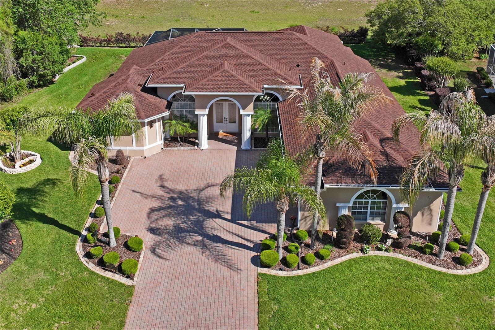 One or more photo(s) has been virtually staged. "HOME IS WHERE THE HEART IS"  This Beautifully updated 4BR/3BA/3-car pool home with office in the gated golf course community of Silverthorn. Offering approximately 3,008 sq ft, this home features 12-ft ceilings, crown molding, and wood flooring throughout main living areas and bedrooms, with tile in baths. Renovated kitchen (2025) includes quartz countertops, wood cabinetry, and Samsung stainless appliances: wall oven, microwave/convection oven, induction cooktop, dishwasher, refrigerator, undercounter wine fridge, and sink. All baths feature granite countertops. Owner’s suite offers 2 walk-in closets, double vanities, garden tub, and large walk-through shower. Updates include new roof (2024), 5-ton A/C (2022), family room fireplace (2025), and pool heater/pump (2025). Enjoy a screened, self-cleaning pool, pavered outdoor spaces, outdoor fireplace, and preserve/fairway views. Smart features include Wi-Fi garage access, Wi-Fi irrigation, 4 PoE wired access points, Z-Wave/Zigbee switches, Hubitat controller, and media/network room with whole-home speaker wiring. Silverthorn amenities include clubhouse, golf, fitness center, pool, tennis, pickleball, playground, and more. HOA includes Spectrum 500MB internet and cable. Close to Suncoast Parkway, shopping, and dining.