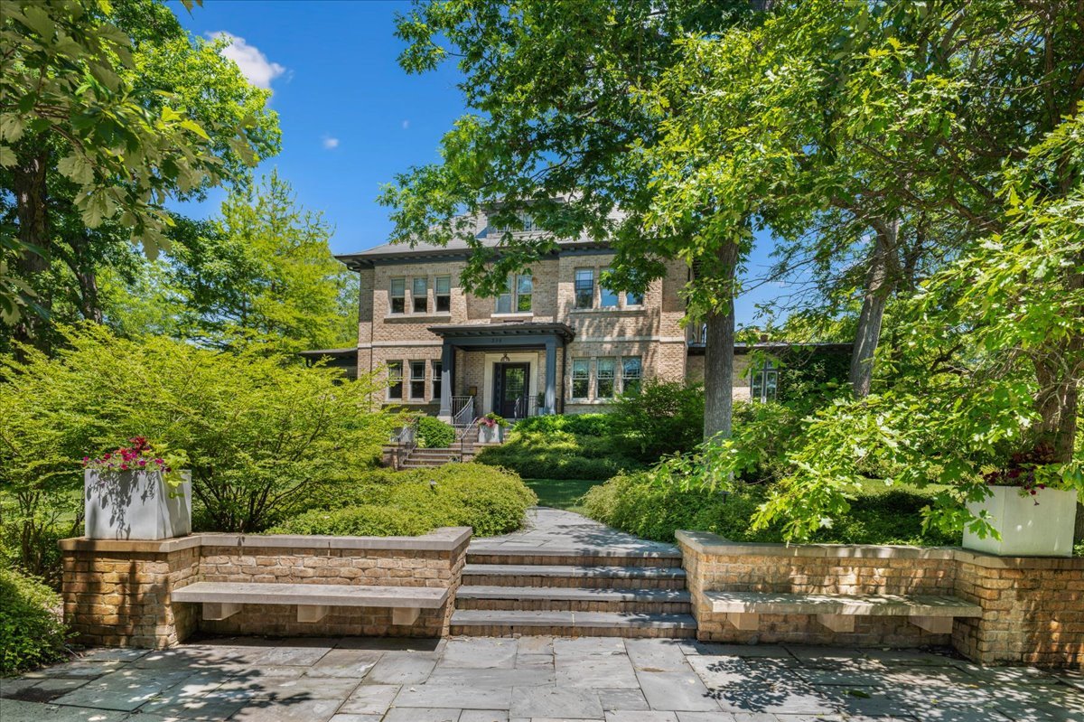 What's behind the timeless classic brick facade of this East Glencoe home lies an unexpected world of glamorous high-end design with a beautiful preservation to the architectural heritage of this 1912 estate. Majestically perched above high on a rare .78 acre corner lot wrapped in a tapestry of mature trees, sculpted hedges, and lush perennial gardens, all 4 levels have been completely reimagined in a youthful vibe & rebuilt with the finest craftsmanship with no expense spared.  From restored stained glass windows, marble grey & white entry with lacquered moldings and vibrant matching wallpaper to the phenomenal 3-story gym with sport court, wellness area and weight room, there are too many things to fall in love with as every room reveals a new surprise. Formal foyer leads to all the entertainment spaces with a gallery-worthy living room, to den, and then elegant dining to kitchen. This is one savvy custom Chef's kitchen with a matching butler's pantry and sleek command center, as it's right out of Elle Decor magazine. Relax and cook at the same time in the beautiful solarium breakfast room or step outside to the terraced patio for your morning coffee overlooking the lush gardens & patio. Huge family room adjacent to kitchen with limestone FP, artistic custom built-ins, and vaulted ceilings sets the mood for your nightly Love Island episode! Second and third floors with all redone high-end baths with Callista, Waterworks & Ann Sacks. Posh primary with hotel-level bath, customized closet with 2 private sections, fab sitting room with FP flanked by custom bookshelves, a true retreat. Laundry room and 2 other beds complete this floor. Third-floor retreat with decked-out hang space, 3 beds, and 2 baths. Step down to this unique lower level with direct access to heated 2 garage, a huge built-out mudroom, game room, 7th bed and bath, and of course, the gym that is fit for a professional athlete. Best yet, plan for your massage after hitting some cardio and playing basketball on your indoor court. The separate coachhouse now serves as a game room with full bath and lower level with pandora glass doors that open right onto the outdoor sports court. Gorgeous grounds with rolling greens surrounding this entire entertainment oasis. This is more than a home-it is a private luxury compound where classic elegance meets unapologetic glamour with a touch of athletic power! The pictures don't do this special home justice ...it's simply phenomenal if you are looking for a beautifully done rehab with a soul that outweighs new construction.