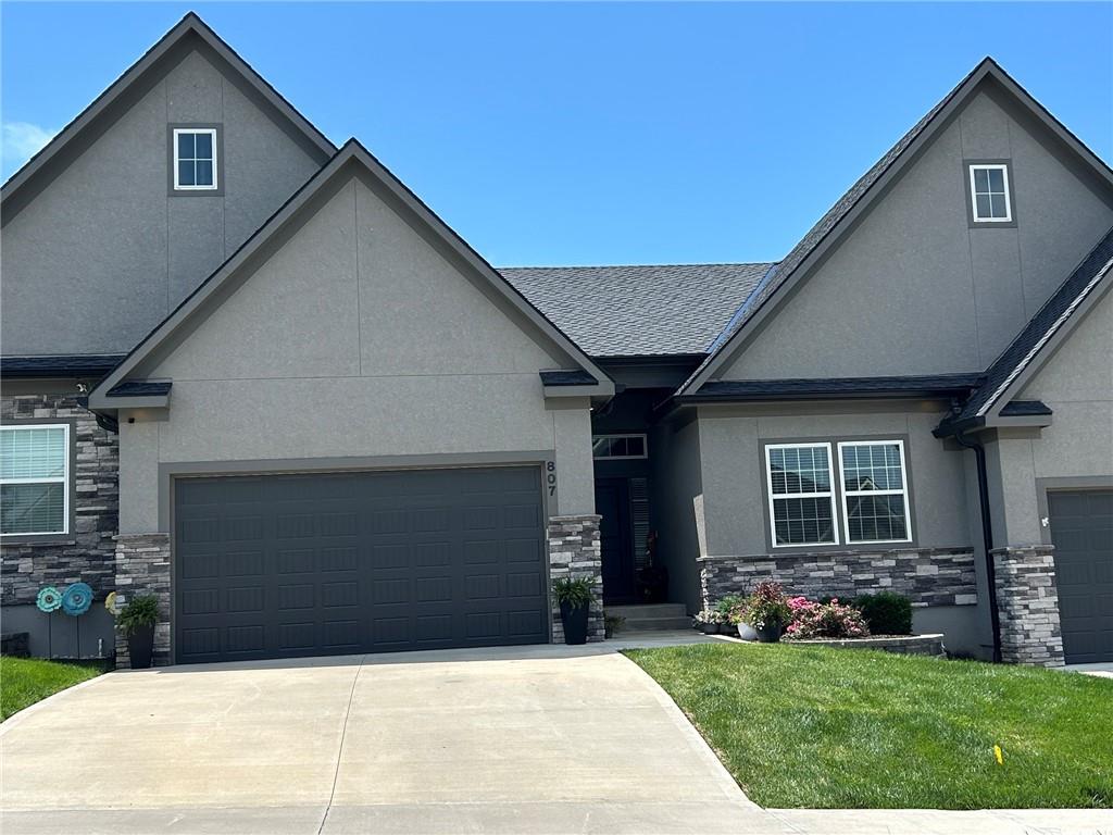 Enjoy easy, maintenance-free living in this custom-built townhouse located in Lakewood’s Chapel Ridge subdivision. Built just three years ago, this one-and-a-half story ranch-style plan offers true main-level living with thoughtful design throughout. The great room features high ceilings, wood floors, and a stone fireplace, opening to a well-appointed kitchen with granite countertops, stainless steel appliances, five-burner gas stove, tiled backsplash, walk-in pantry, and convenient eat-at bar. The main-level dining area walks out to a covered deck with low-maintenance decking, also accessible from the primary suite—perfect for relaxing with minimal upkeep. Main-level laundry adds to the convenience.The main-level primary suite offers a raised ceiling with wood inlay, walk-in closet, and a luxury bath featuring double vanities, added cabinetry for extra storage, and an oversized tiled shower. A finished walkout lower level provides a spacious family room, third bedroom, third full bath, and generous storage, with access to a patio and fenced backyard—ideal for guests or hobbies without daily stairs.Attached two-car garage on the main level. Exterior maintenance, lawn care, and snow removal are included, allowing more time to enjoy Lakewood’s amenities, including two lakes, marinas, swimming pools, tennis courts, and a golf course.