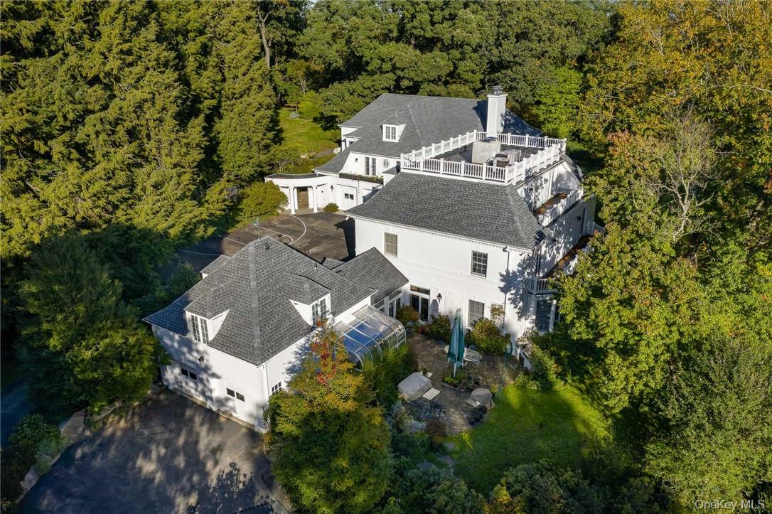 Magnificent multi-generational 7 plus bedroom, 13-bathroom home on 4.5 acres with a heated indoor swimming pool and spa. This expansive home has two distinct wings (original home built in 1936 and a new wing built in 1991) and lives like two independent houses, each with their own utilities, kitchens and laundry room and are joined by a common front foyer. The original house has an oversized living room with French doors leading to terrace, a formal dining room, an updated kitchen with separate breakfast area, and mud room. On the second level is the primary suite with dressing room and two renovated bathrooms, two additional ensuite bedrooms and laundry room. And the third floor has two sunny offices with balconies and a full bathroom, The new addition has an open updated kitchen/great room with balcony overlooking yard, a large living room/dining room and a primary suite with walk in closet and full bathroom. On the second level are two additional bedrooms, a bonus room and a full bathroom. Amazing 60’  Shoreline pool and spa in a expansive room with wall of window, a changing room and full bath, and is adjacent to a great recreation room/gym. Special features include abundant windows, high ceilings, extensive woodwork and moldings, wood floors, 3 fireplaces, multiple balconies, generator, 4 car garage and a private guest wing with separate entrance. The outdoor space is exceptional with meadows, sprawling lawns, specimen trees, cutting gardens, and stone terraces. Meticulous condition- roof (2020), AC condensers (2020), Boilers (2021/2023), new driveway (2026), new 7-person septic (2026). Full basement with high ceilings offers excellent storage. Full house generator. This ultra-private home is in a prime location and located very near to Armonk town center. Byram Hills Schools