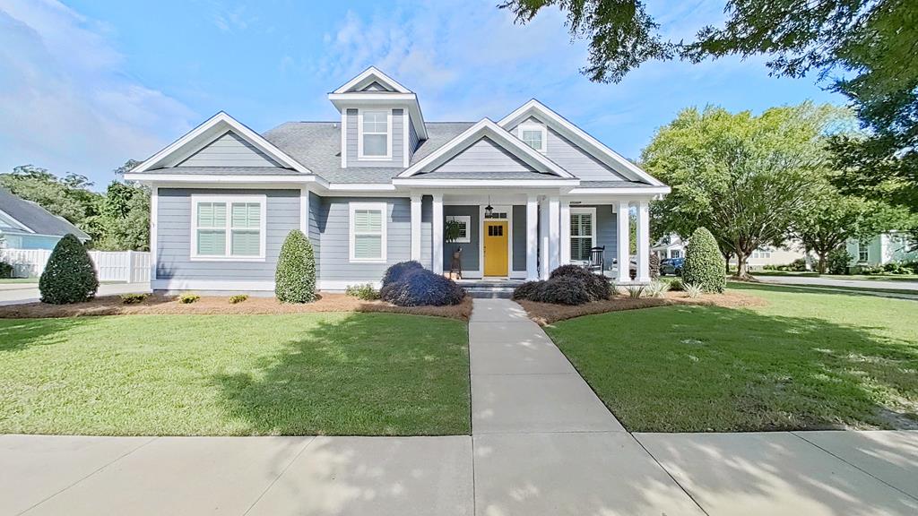 Beautiful home with outstanding curb appeal, highlighted by a stunning stone front porch. Step inside to find a formal dining room and a spacious living room featuring a cozy gas log fireplace, custom built-ins, plantation shutters, and French doors leading to a covered screened porch with TV hookups—perfect for entertaining or relaxing. The kitchen offers abundant cabinet space, a convenient breakfast bar, and a charming breakfast nook. The primary suite is conveniently located on the main level, along with an additional bedroom that would make an ideal nursery, home office, or playroom. A half bath and well-appointed laundry room with shelving and cabinetry complete the first floor. Upstairs you'll find three additional bedrooms plus a large bonus room, providing plenty of space for family, guests, or hobbies. Two of the bedrooms share a convenient Jack-and-Jill bathroom and additional full bath and bonus room upstairs.  Step outside to enjoy the private, fenced backyard featuring a beautiful stone patio, ideal for grilling and outdoor gatherings. This home offers the perfect combination of comfort, functionality, and inviting indoor and outdoor living spaces.